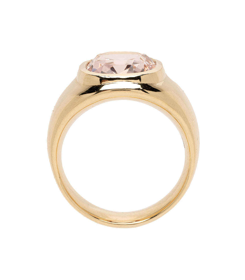 Gold ring with a pink gemstone on a white background