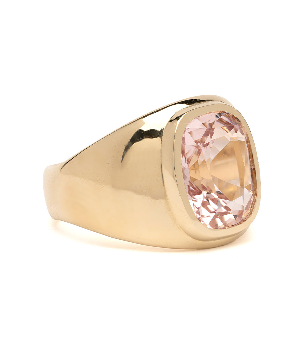 Gold ring with a pink gemstone on a white background