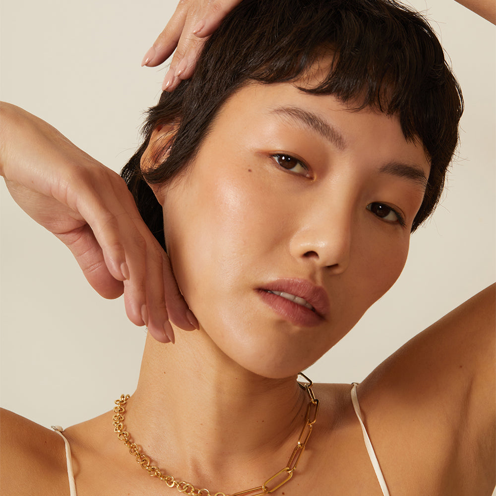 The Power Couple CN-C3 gold necklace on model with linked oval stations under soft studio light