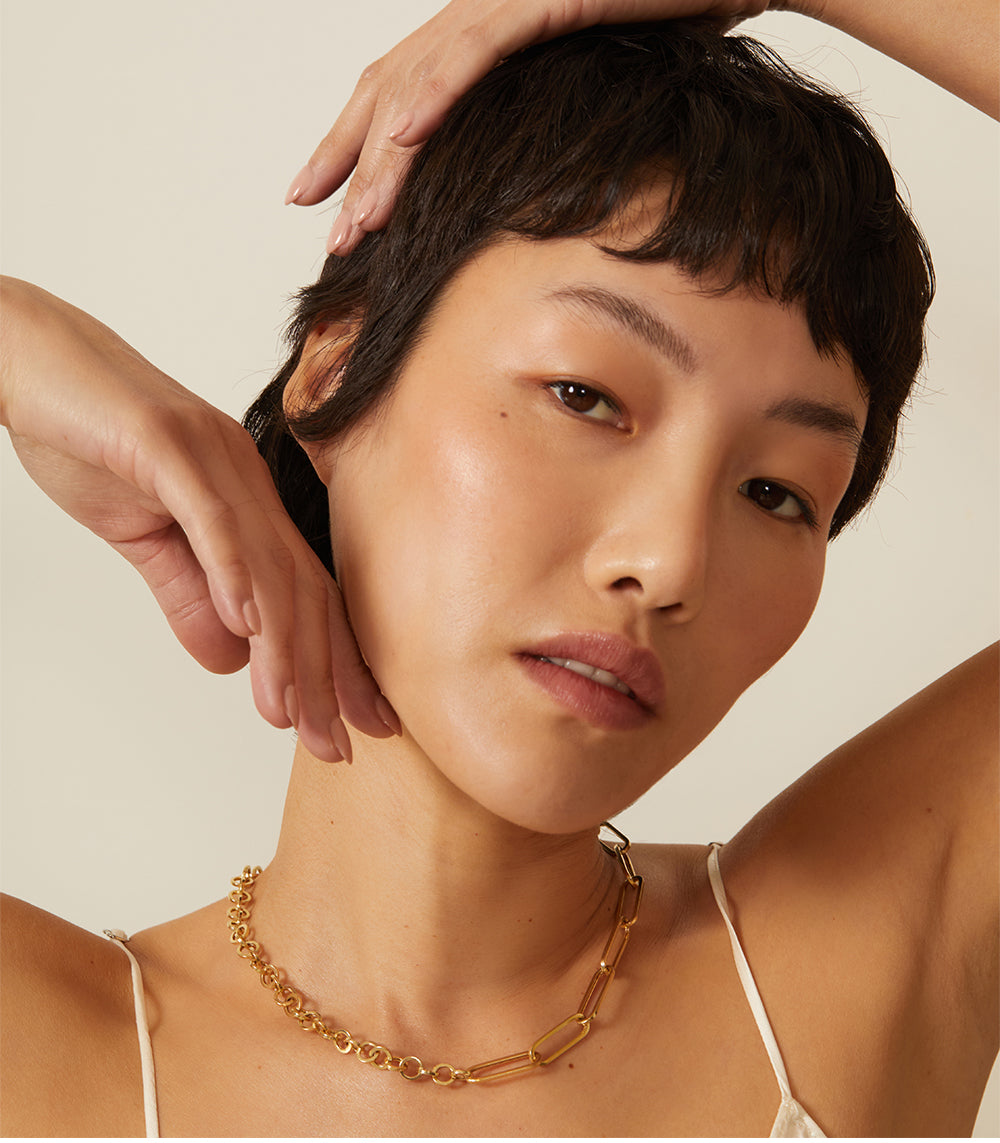 The Power Couple CN-C3 gold necklace on model with linked oval stations under soft studio light