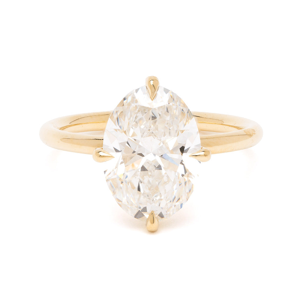 Billie Sofia Kaman gold engagement ring with polished band and oval cut diamond center