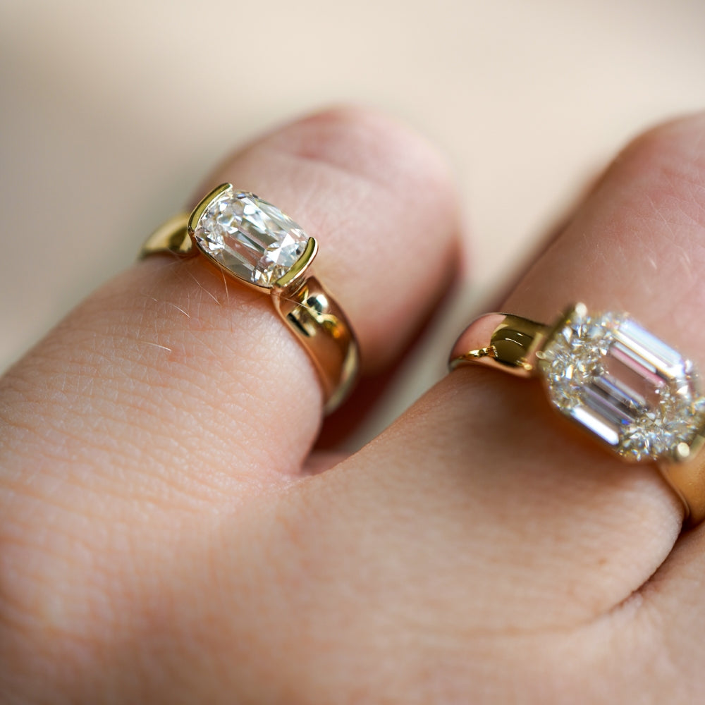 Bardot Pinky Sofia Kaman ring in gold with a square-cut sparkling stone on a finger in soft light