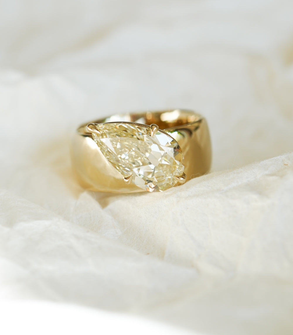 Lana by Sofia Kaman gold ring with cushion-cut diamond center on soft white fabric