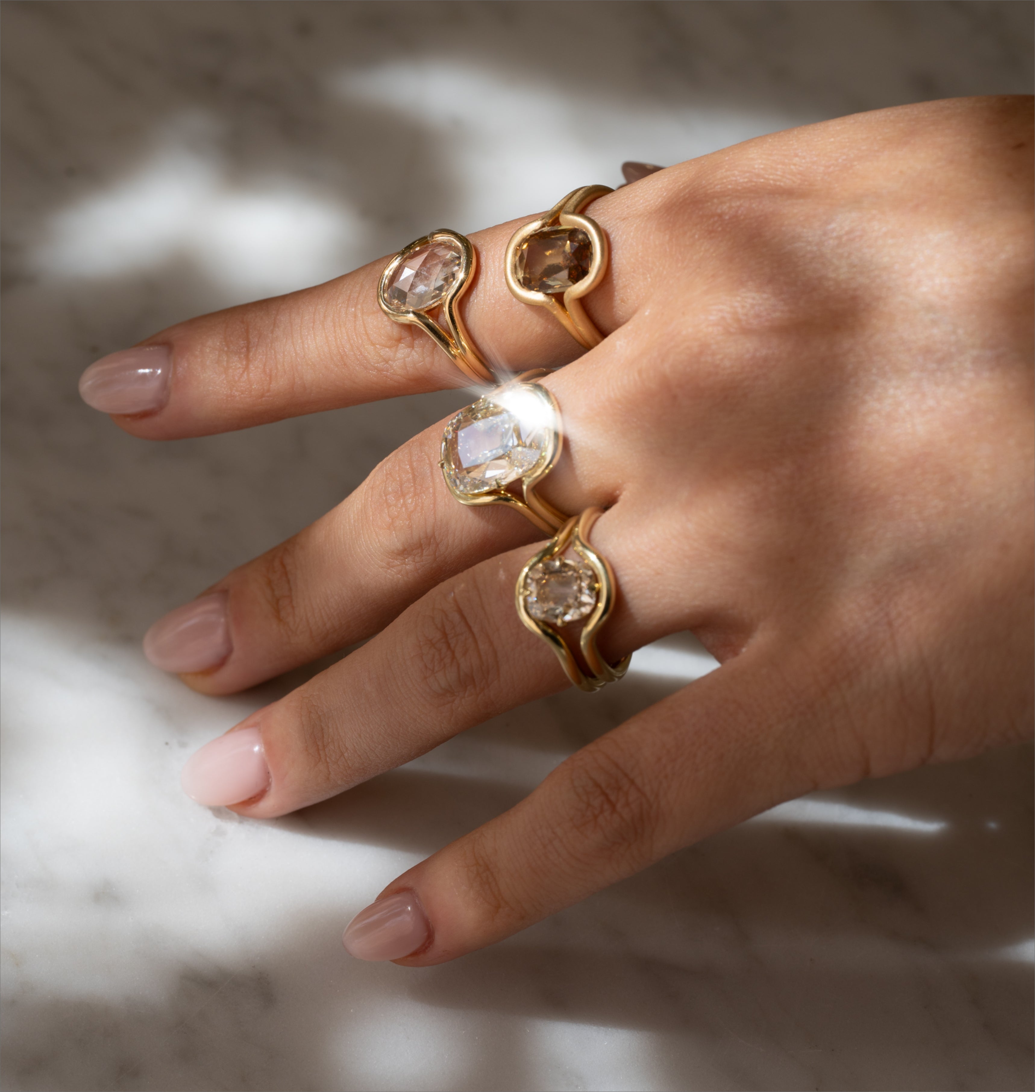 Unique engagement ring with asymmetrical oval setting and warm-gold band, boho engagement rings on fingers