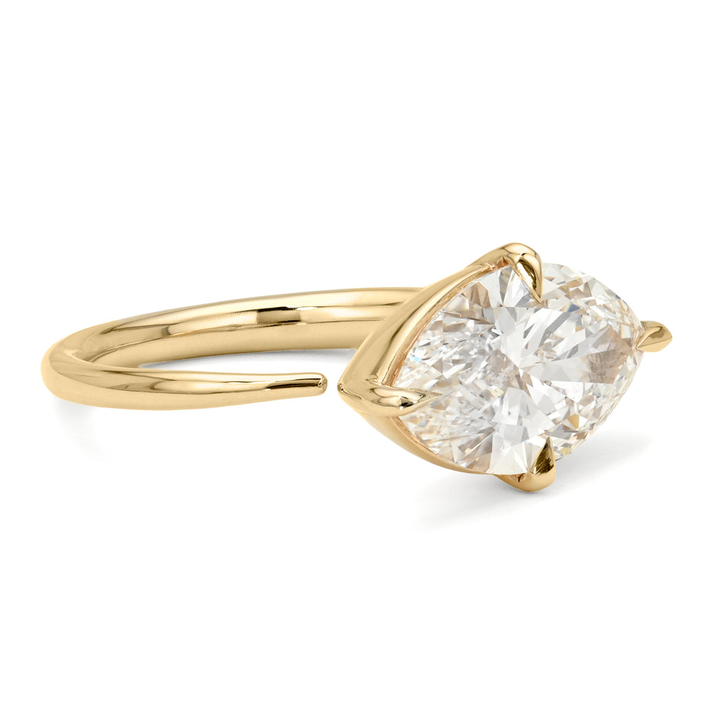 A yellow gold solitaire engagement ring featuring a marquise-cut white diamond in a prong setting, shown on a clean white background.