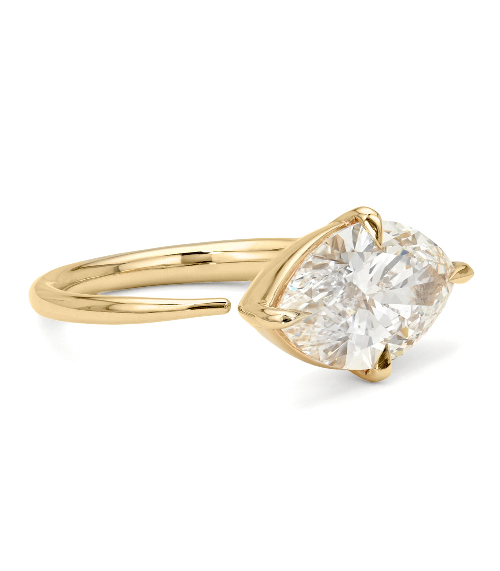 A yellow gold solitaire engagement ring featuring a marquise-cut white diamond in a prong setting, shown on a clean white background.