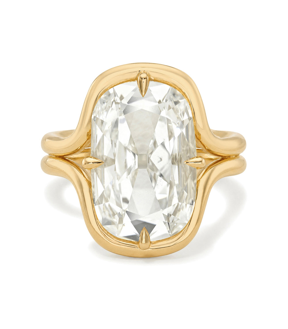 A yellow gold ring featuring a large, cushion-cut clear gemstone in a prong setting, shown against a plain white background.