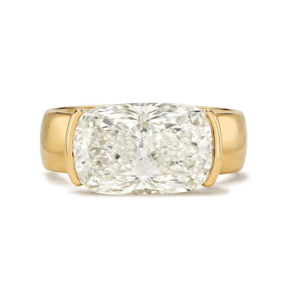 A cushion-cut diamond ring set in a yellow gold band, photographed against a clean white background.
