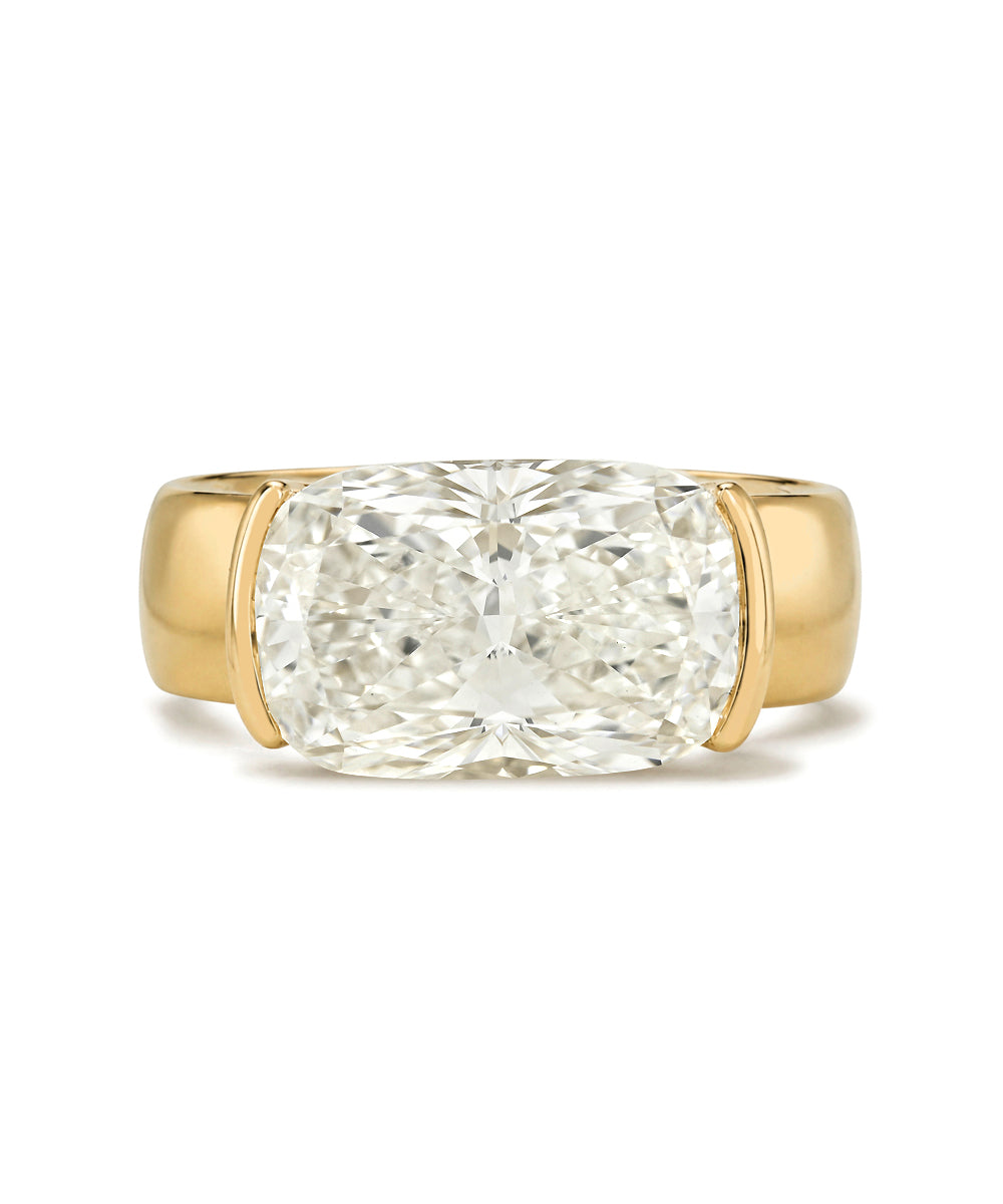 A cushion-cut diamond ring set in a yellow gold band, photographed against a clean white background.