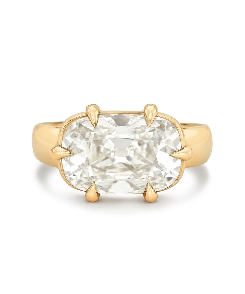 A yellow gold ring featuring a large elongated cushion-cut diamond in a four-prong east west setting, shown against a plain white background.