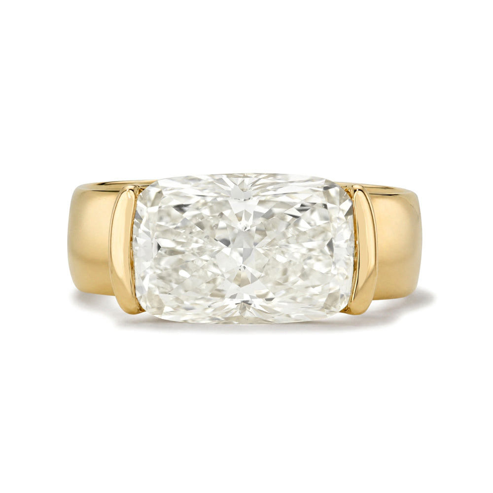 A yellow gold ring featuring a large cushion-cut diamond center stone in a four-prong setting, shown against a plain white background.