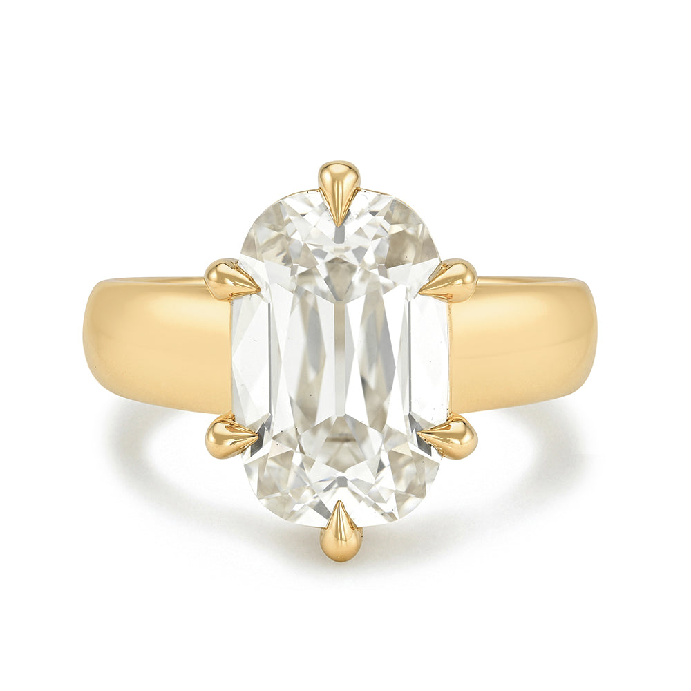 A yellow gold ring featuring a large, elongated cushion old mine-cut diamond in a six-prong setting, shown against a plain white background.