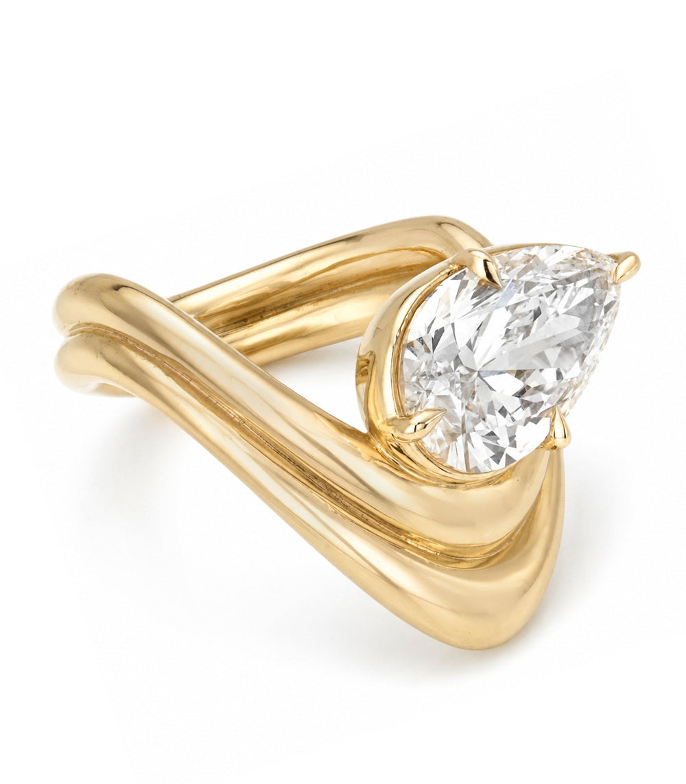 A yellow gold solitaire engagement ring featuring a pear brilliant-cut set in a tilted orientation white diamond in a prong setting with a double contour band shown on a clean white background.