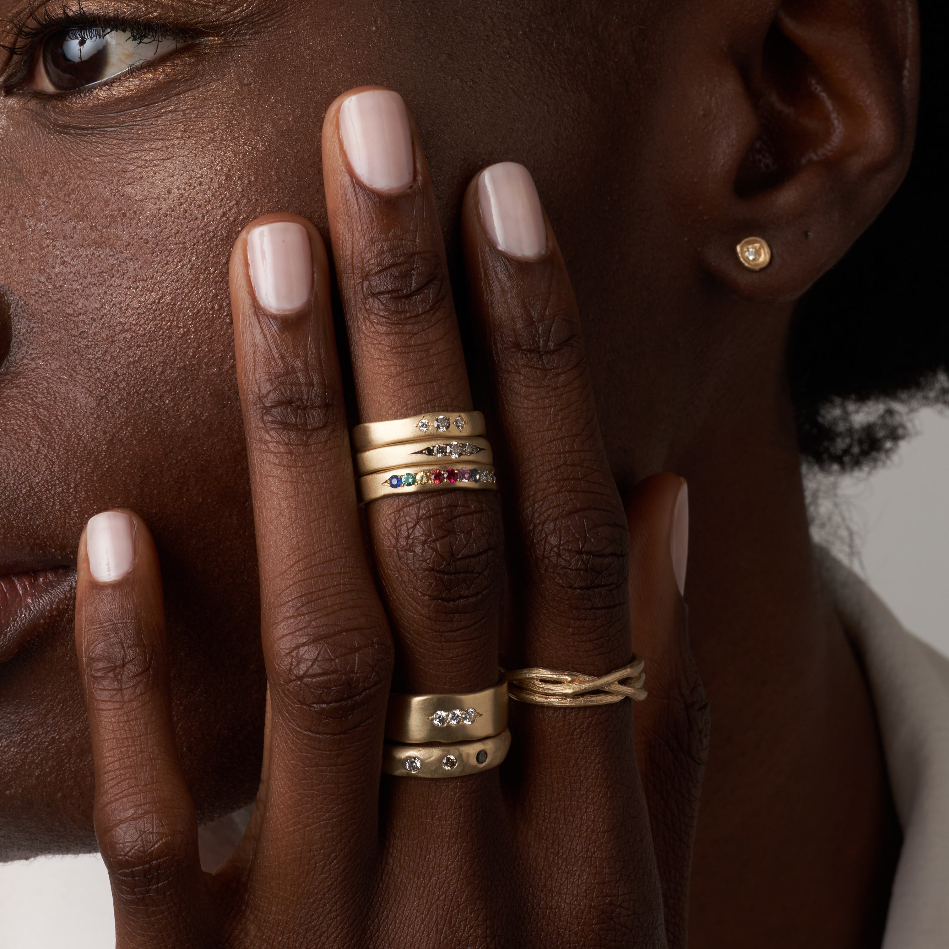 Woven Branches M-R5 gold bands with shiny and matte stacked ring stones on fingertips
