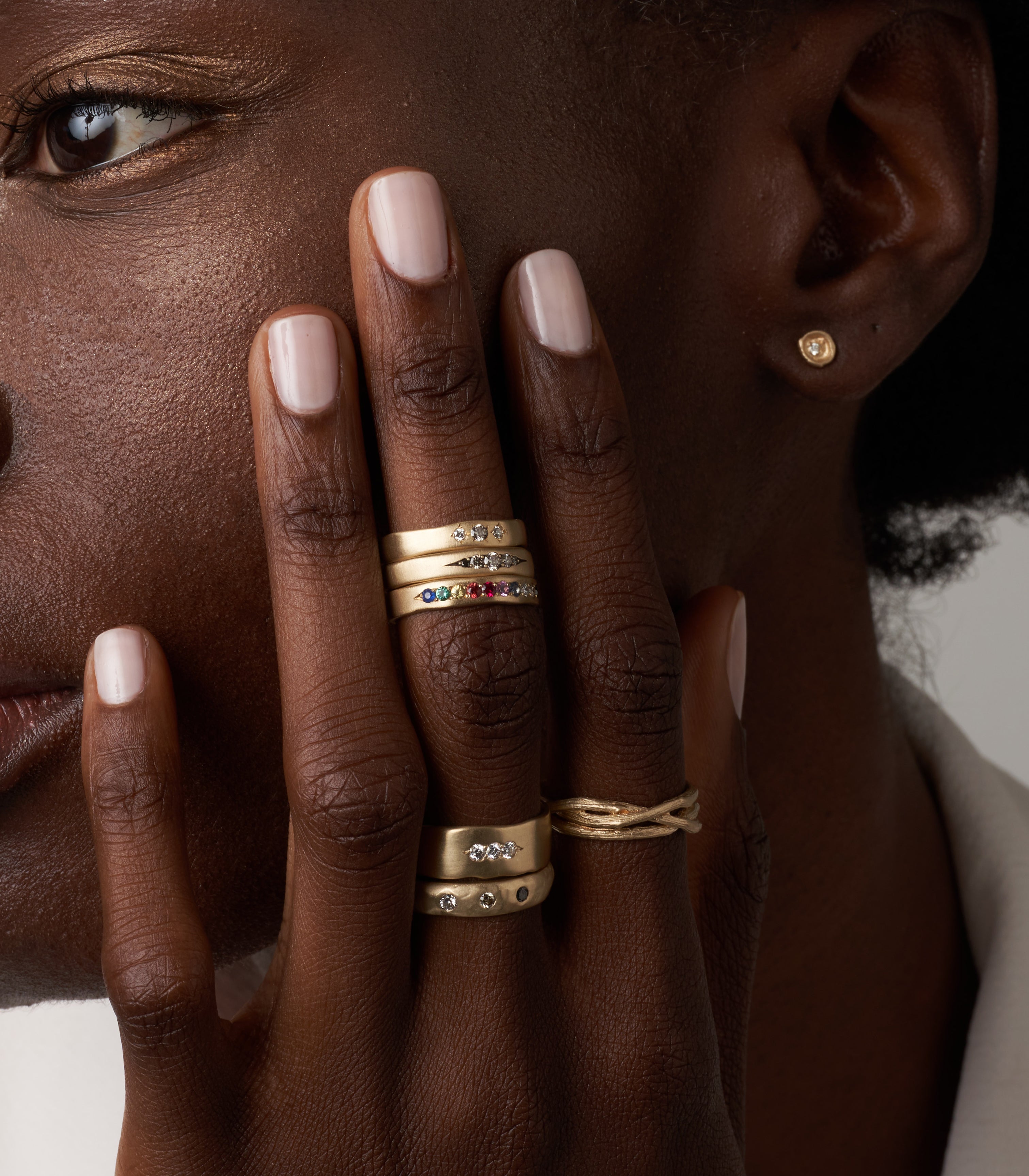 Woven Branches M-R5 gold bands with shiny and matte stacked ring stones on fingertips