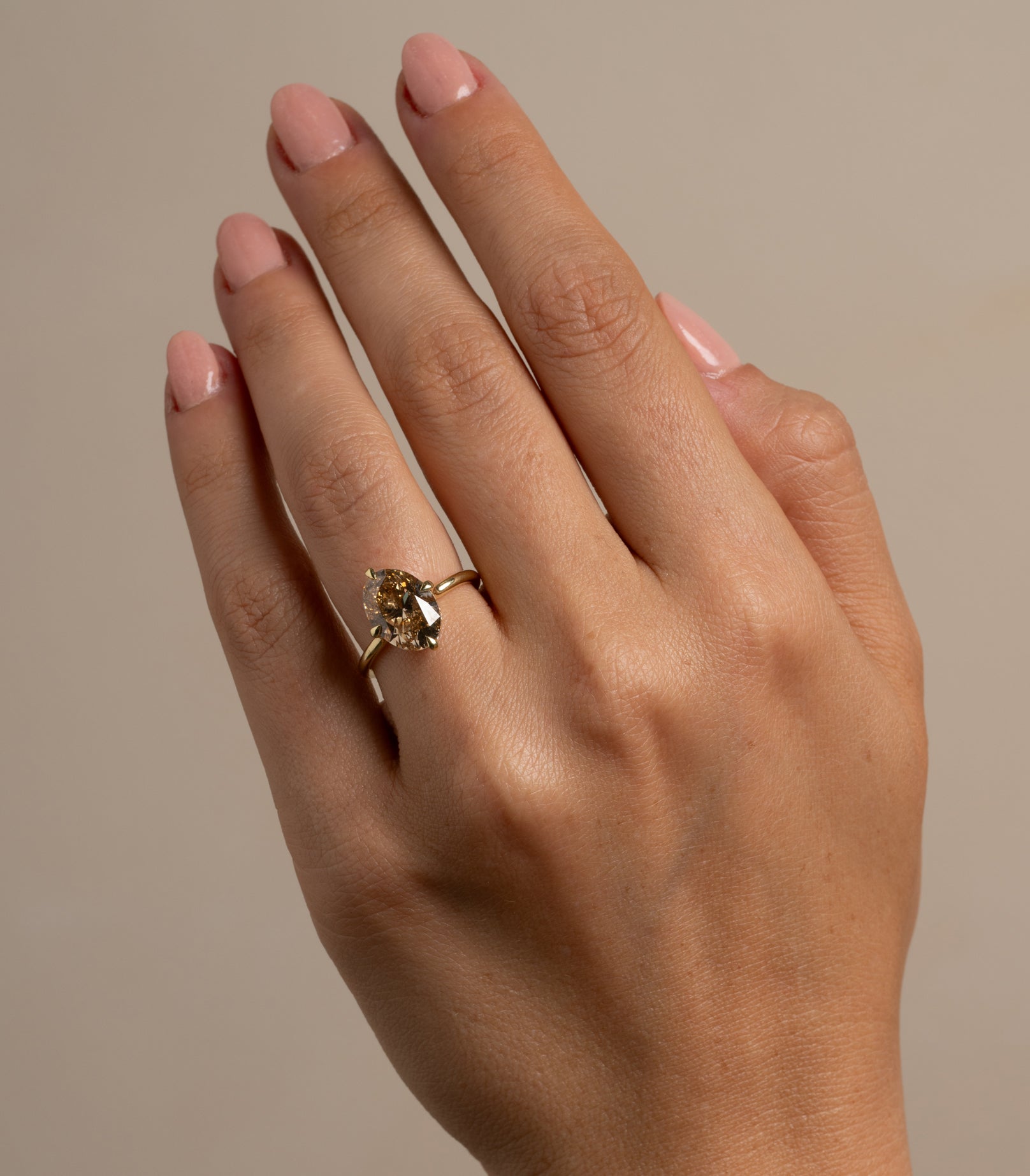 Billie SK-R94-ND-OC-NS-4.01 gold engagement ring with a round champagne-toned center stone on hand