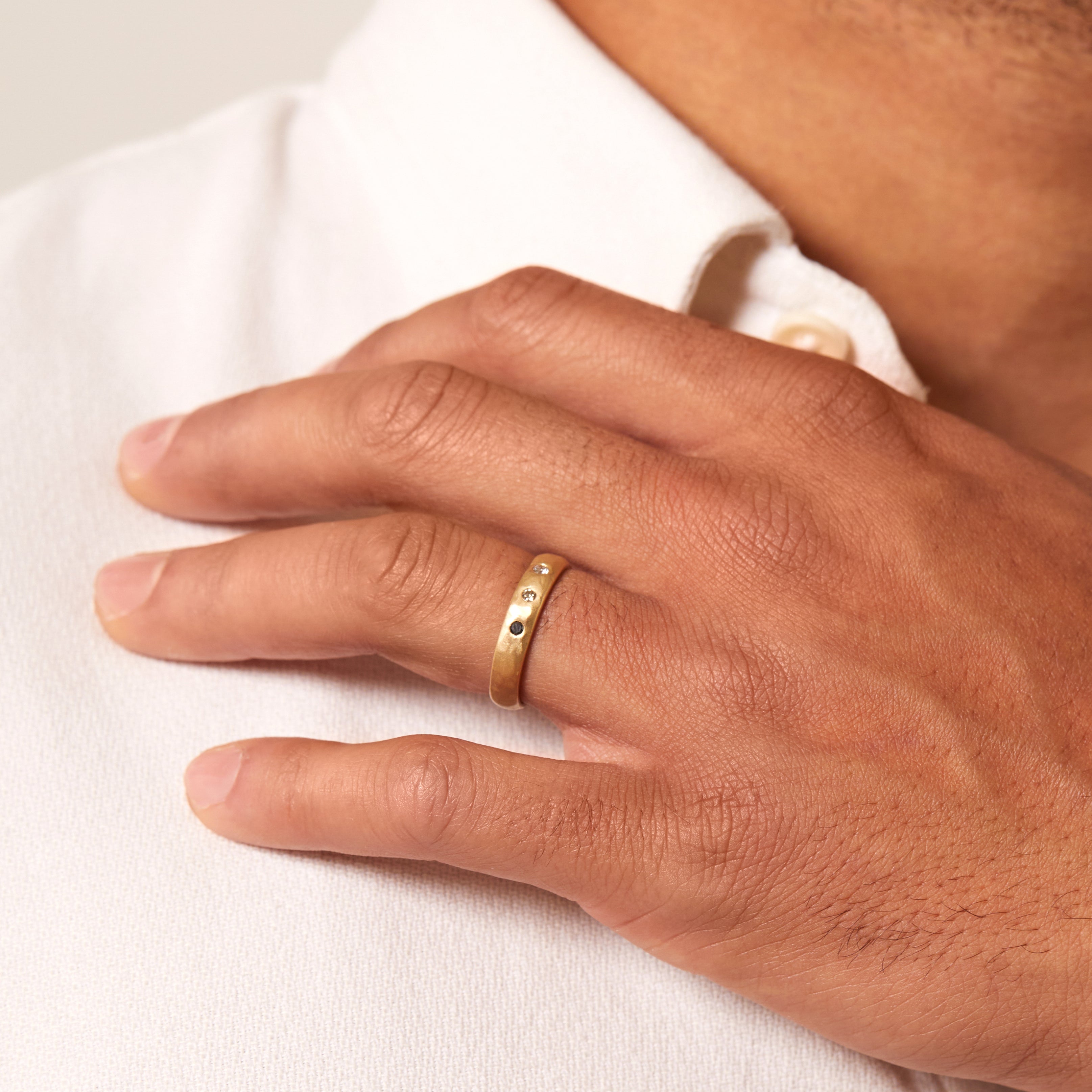 Dusk till Dawn GN-R3 engagement ring gold band with two small stones, worn on a finger