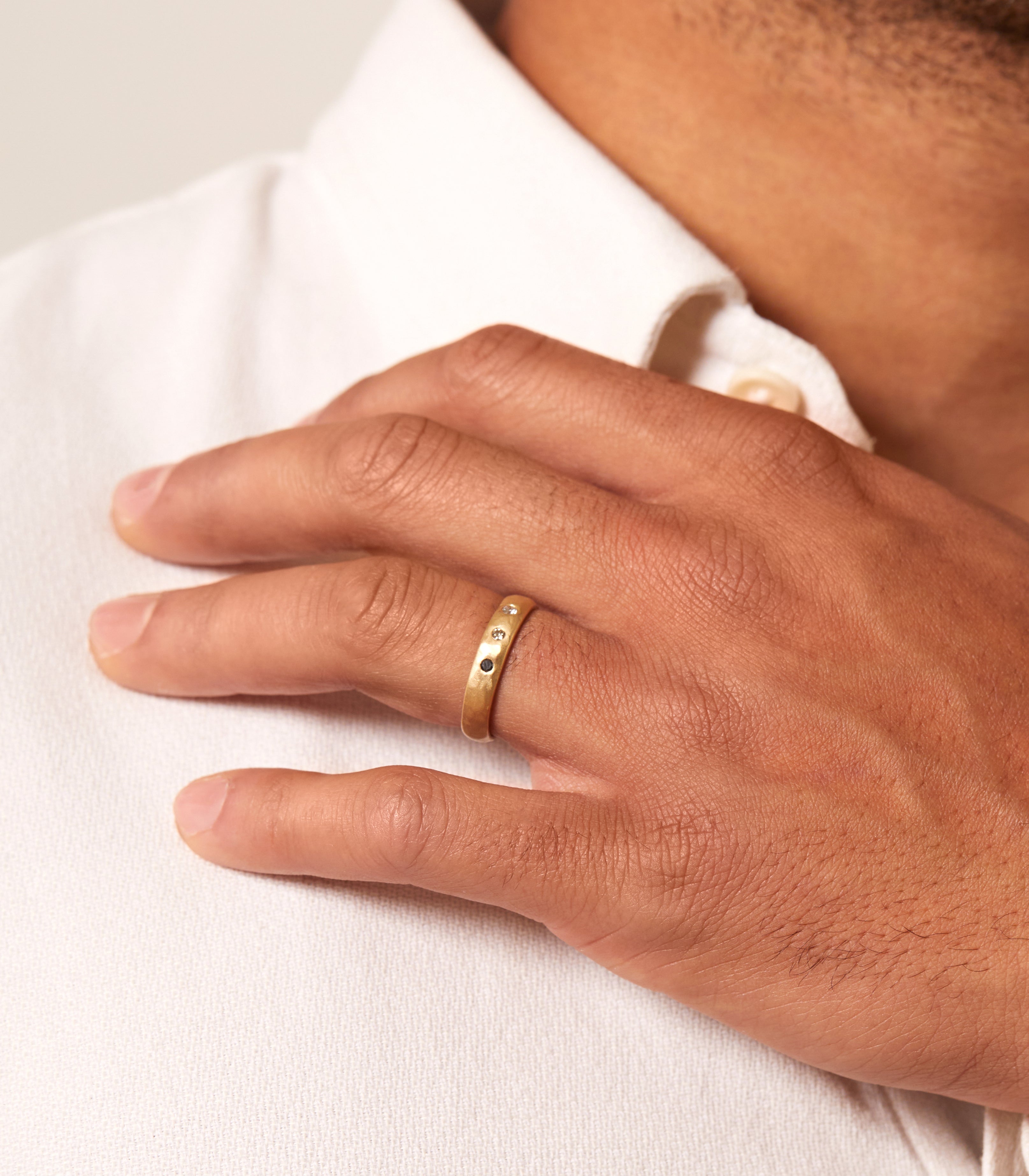 Dusk till Dawn GN-R3 engagement ring gold band with two small stones, worn on a finger