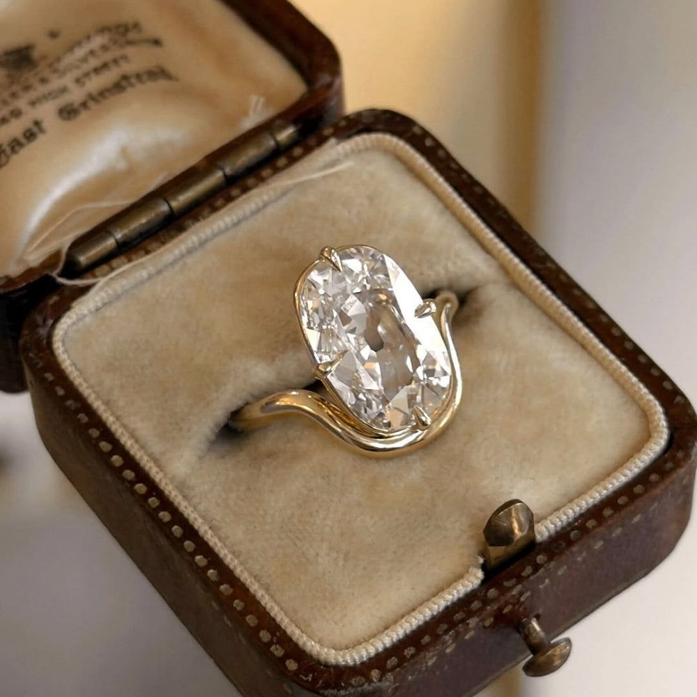 Onda Lite by Sofia Kaman oval diamond gold engagement ring with sculpted bezel on display