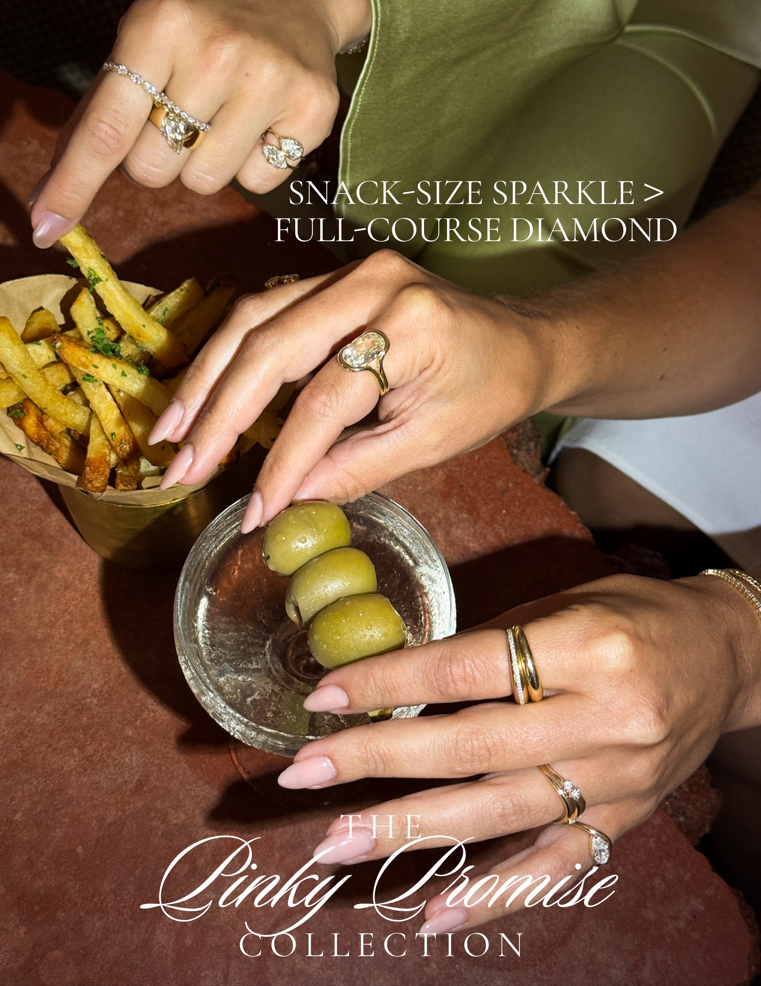 Unique engagement ring with asymmetrical diamond setting on hands beside fries and olives during dinner.