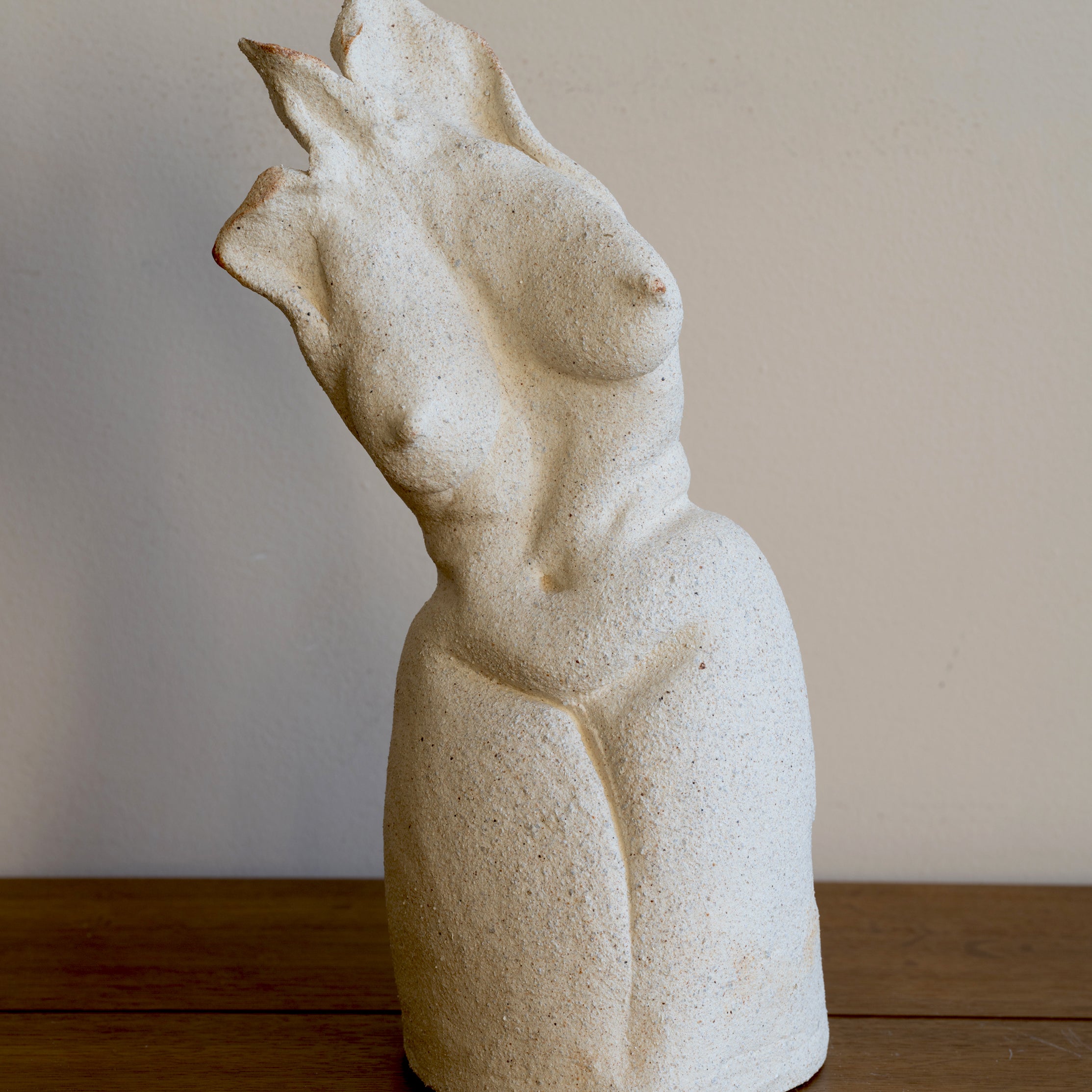 Standing Sculpture I by RM-001, beige stone figurine with carved abstract standing form on wooden floor.