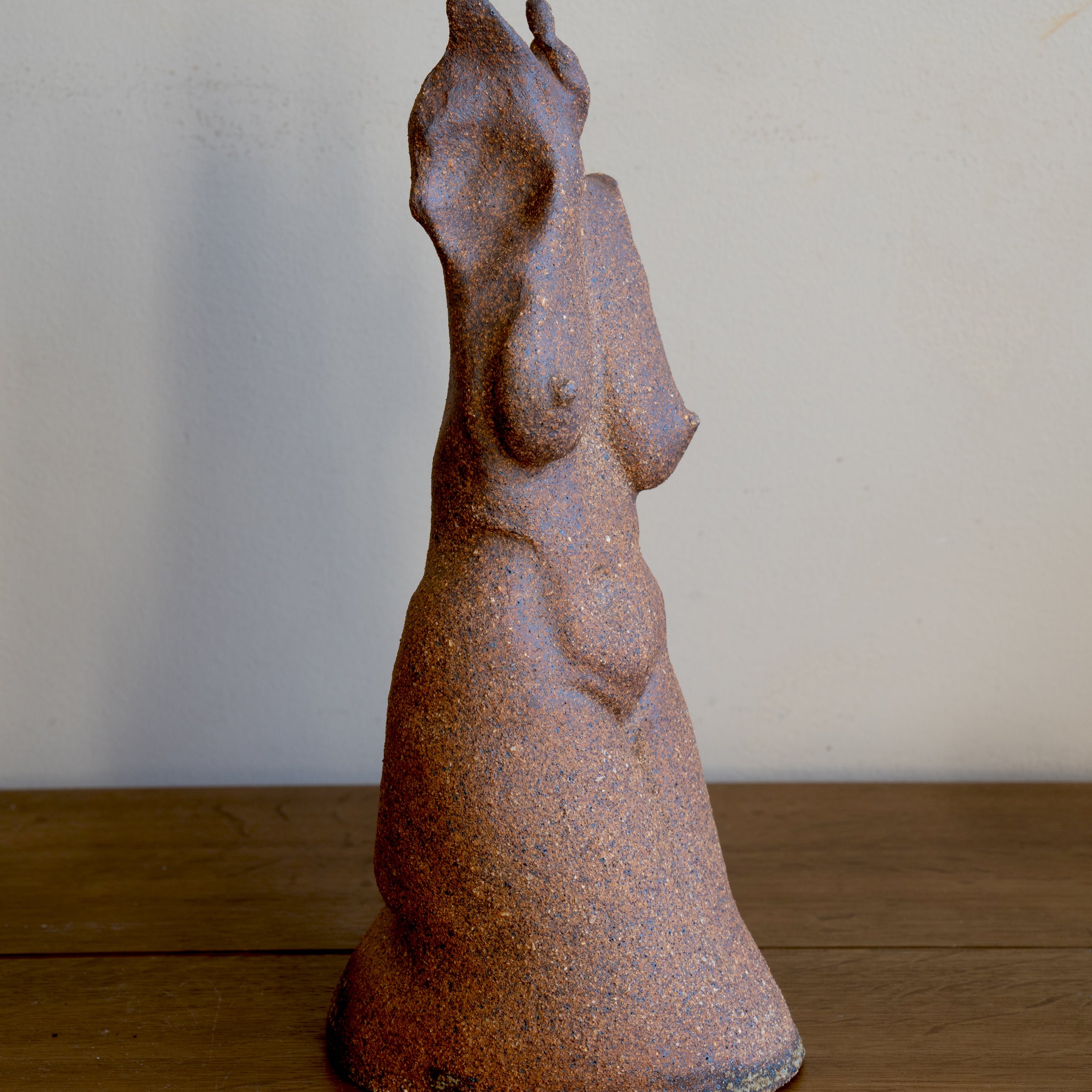 Standing Sculpture II by RM-001 rusted stone-like standing figure sculpture with textured finish in soft light