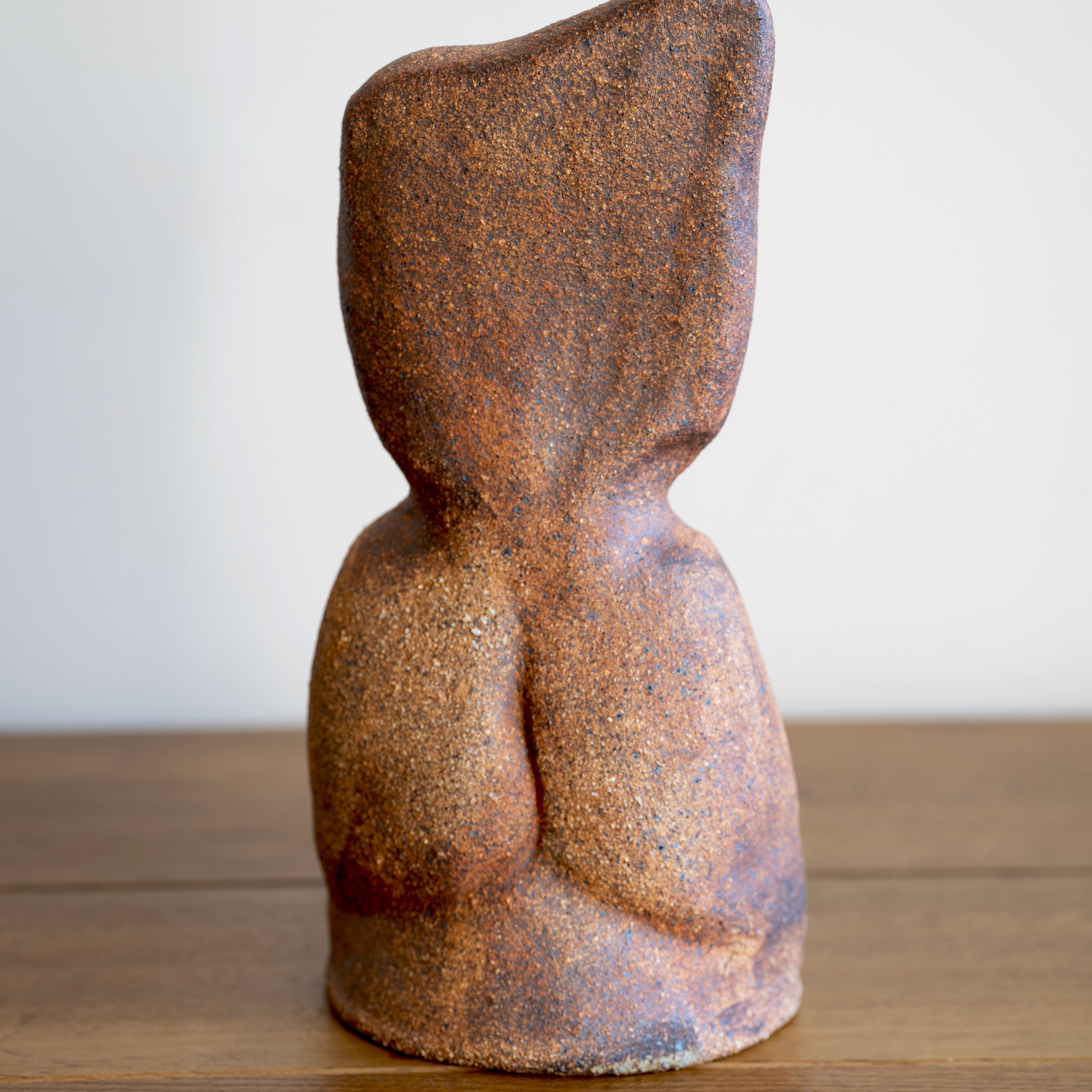 Minimal RM-003 decorative sculpture in textured brown stone finish, shown on a wooden surface