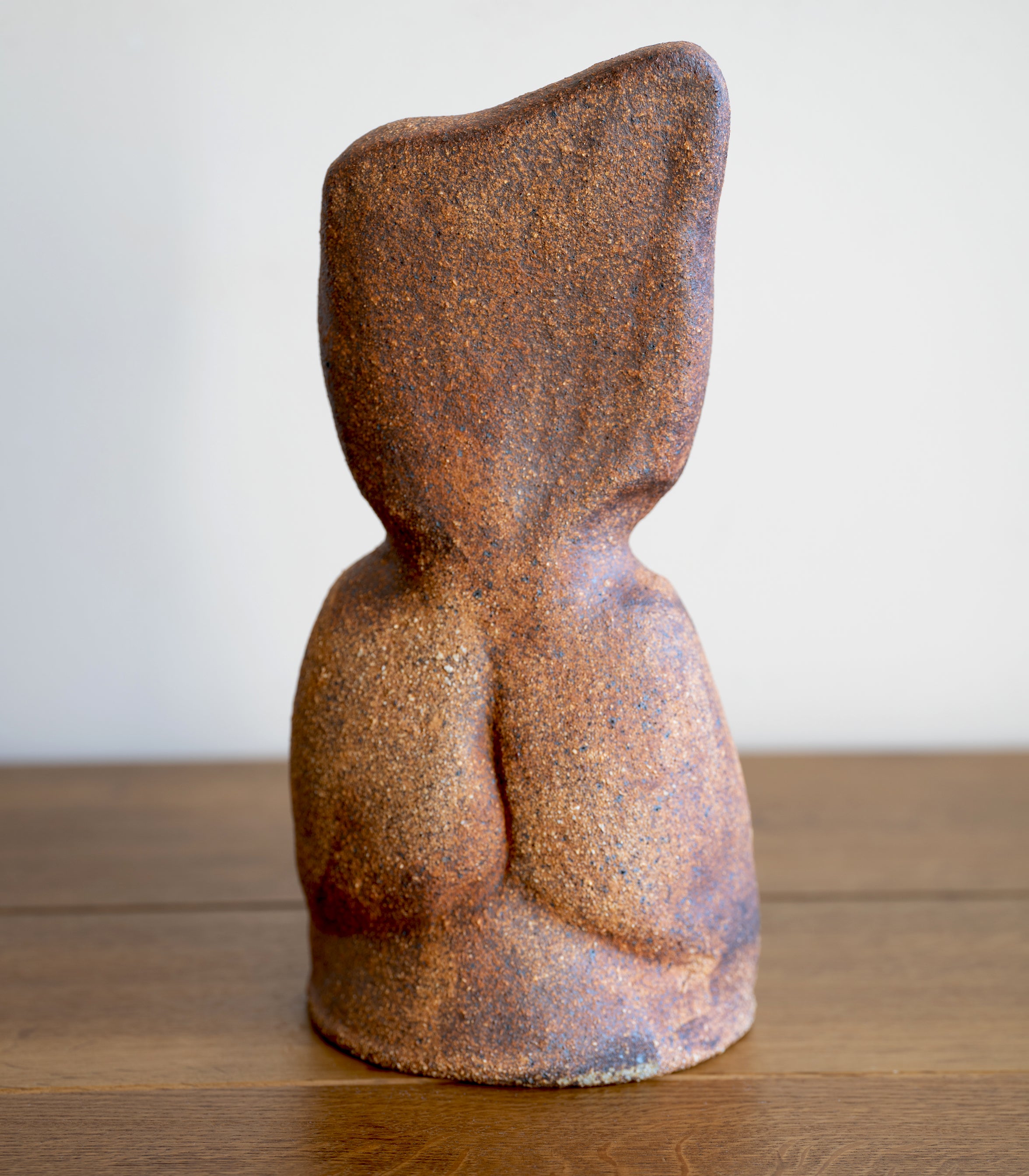 Minimal RM-003 decorative sculpture in textured brown stone finish, shown on a wooden surface