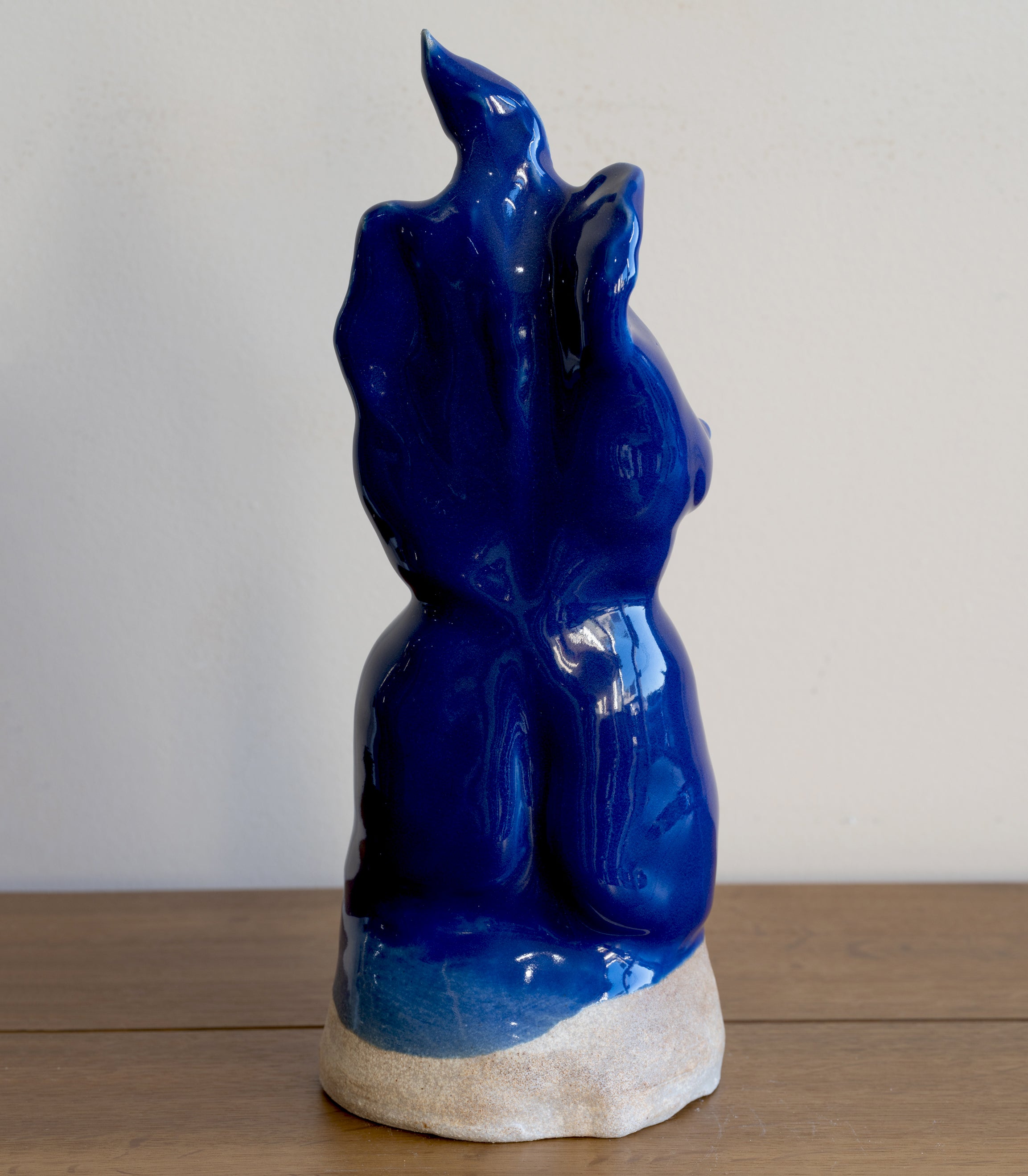 Glazed Sculpture II by RM-005 blue glossy ceramic sculpture on stone base, stylized figure in profile.