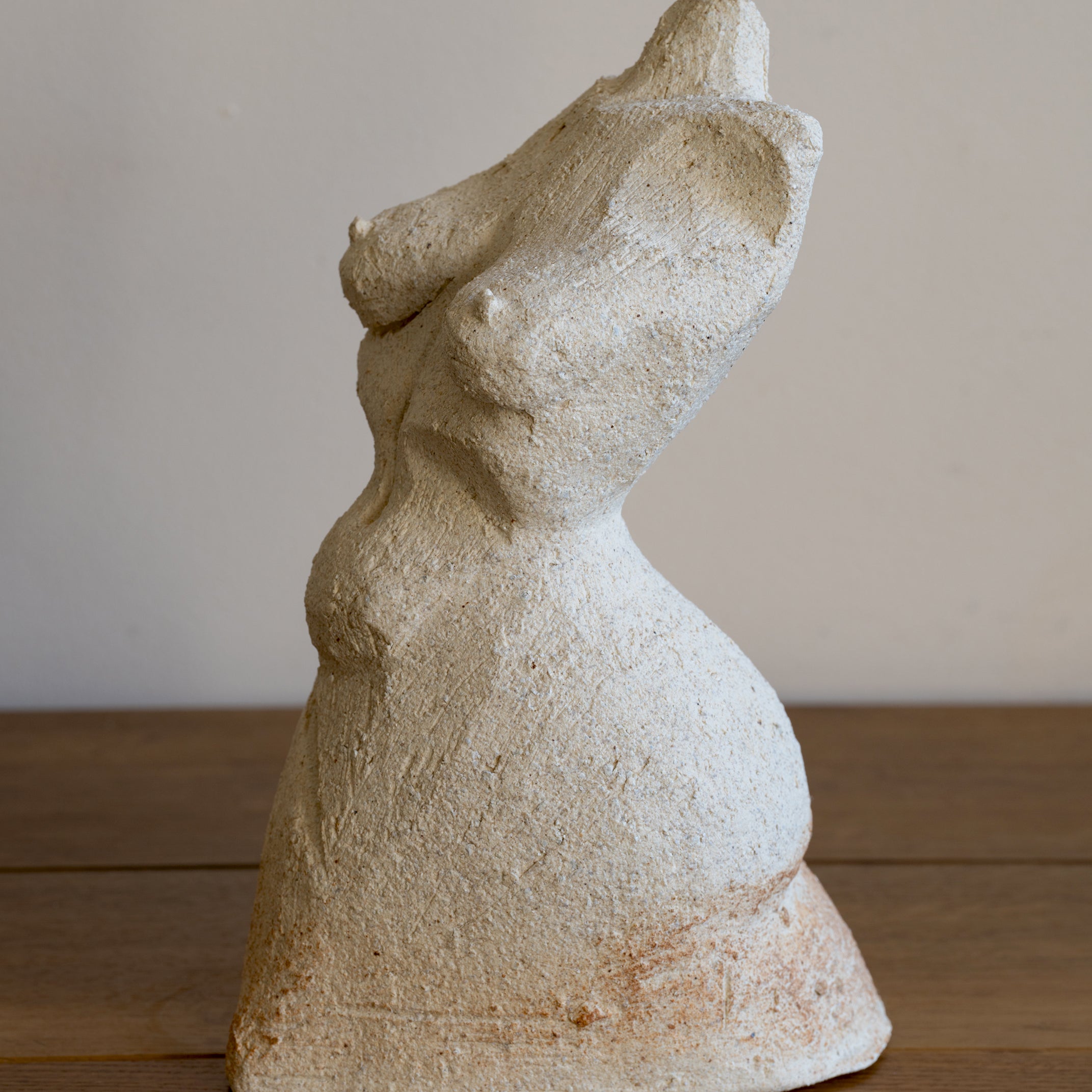 Standing Sculpture III by RM-007 beige stone sculpture with textured finish on wooden floor