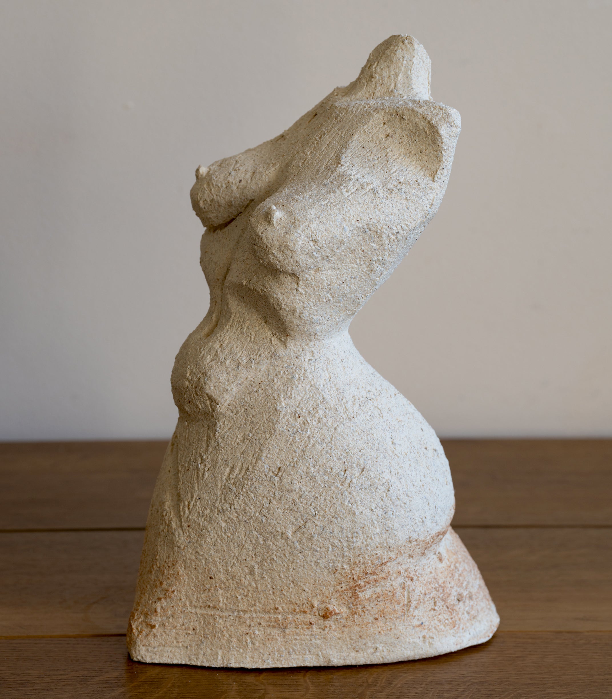 Standing Sculpture III by RM-007 beige stone sculpture with textured finish on wooden floor