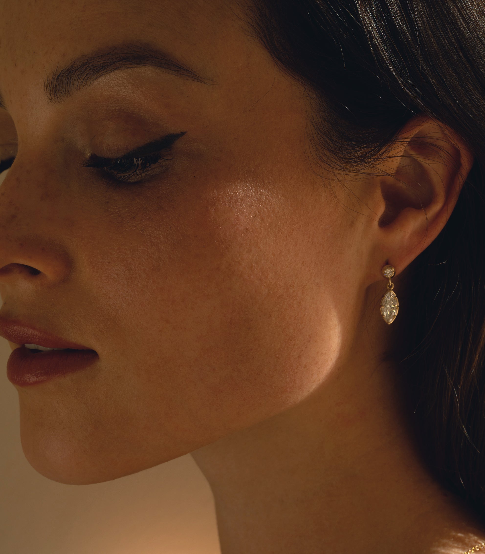 Gigi Earrings by SK-E117-LGD-MB-1.00, gold drop earrings with sparkling round stones in warm light