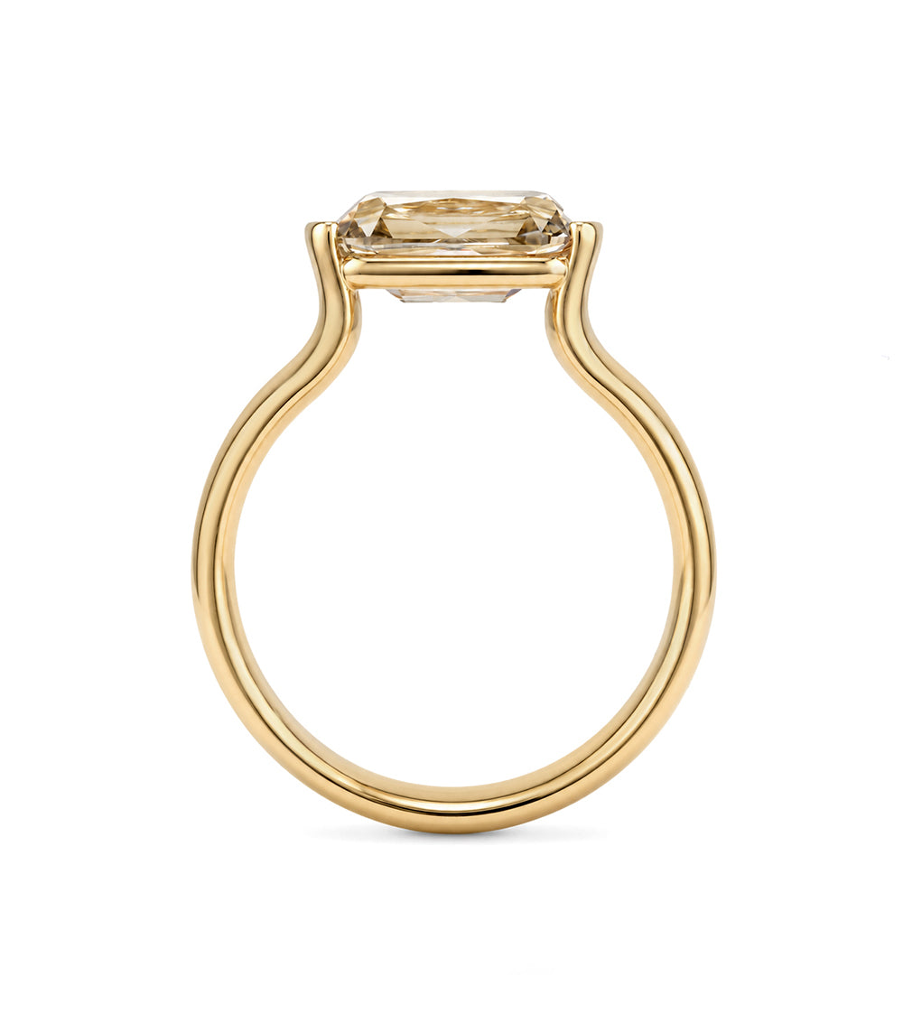 profile view of a old mine cut elongated cushion champagne lab diamond ring set east west in a half bezel with a thick 14K yellow gold band 