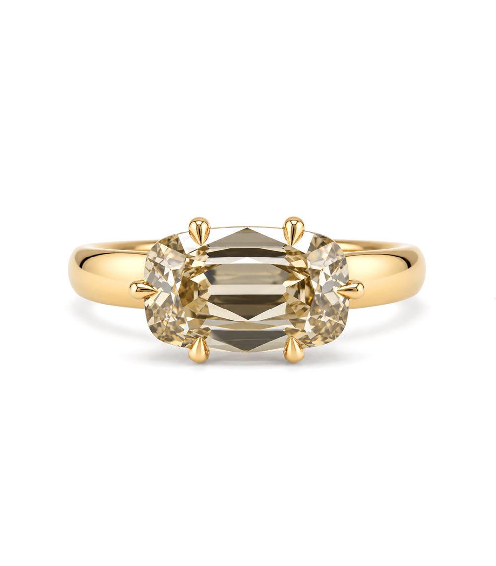 a front view of a warm, toasted colored lab diamond ring set east to west with 6 eagle claw prongs, set low on a wide and tapered band. 