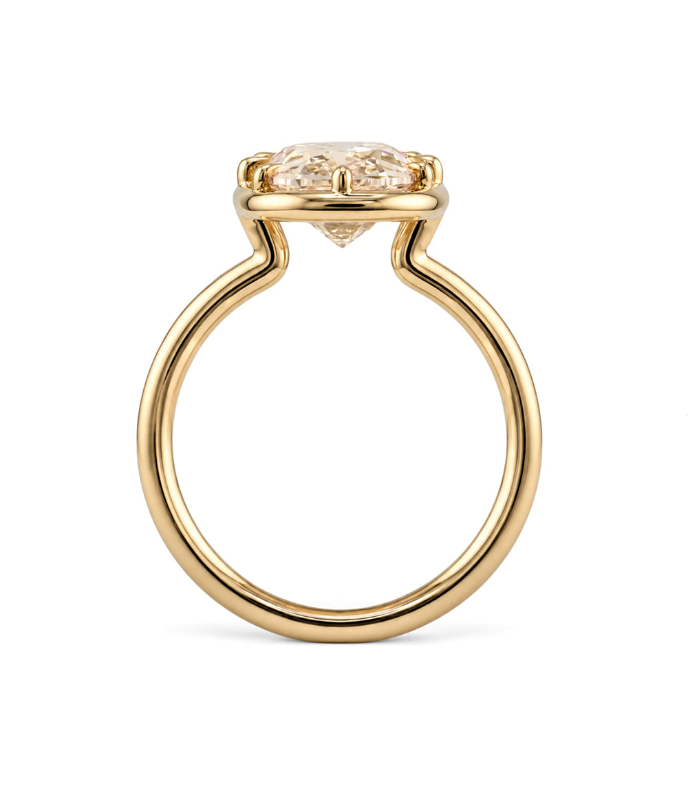 a profile view of a champagne colored old mine cut elongated cushion lab diamond in an antique style setting with claw prongs in 14K yellow gold