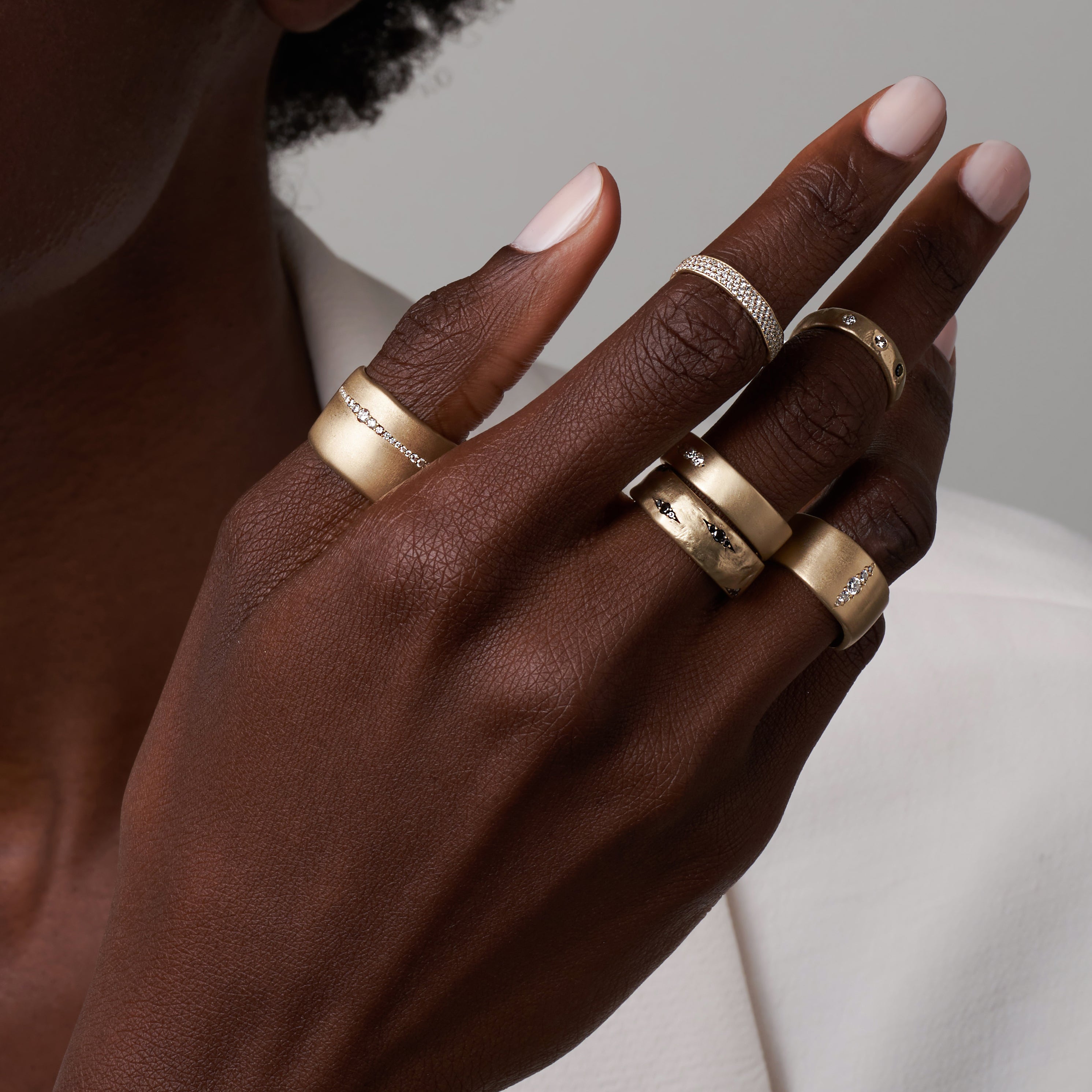 Dark and Mysterious GN-R1 shiny gold band rings with matte edges on a hand, sparkling stones