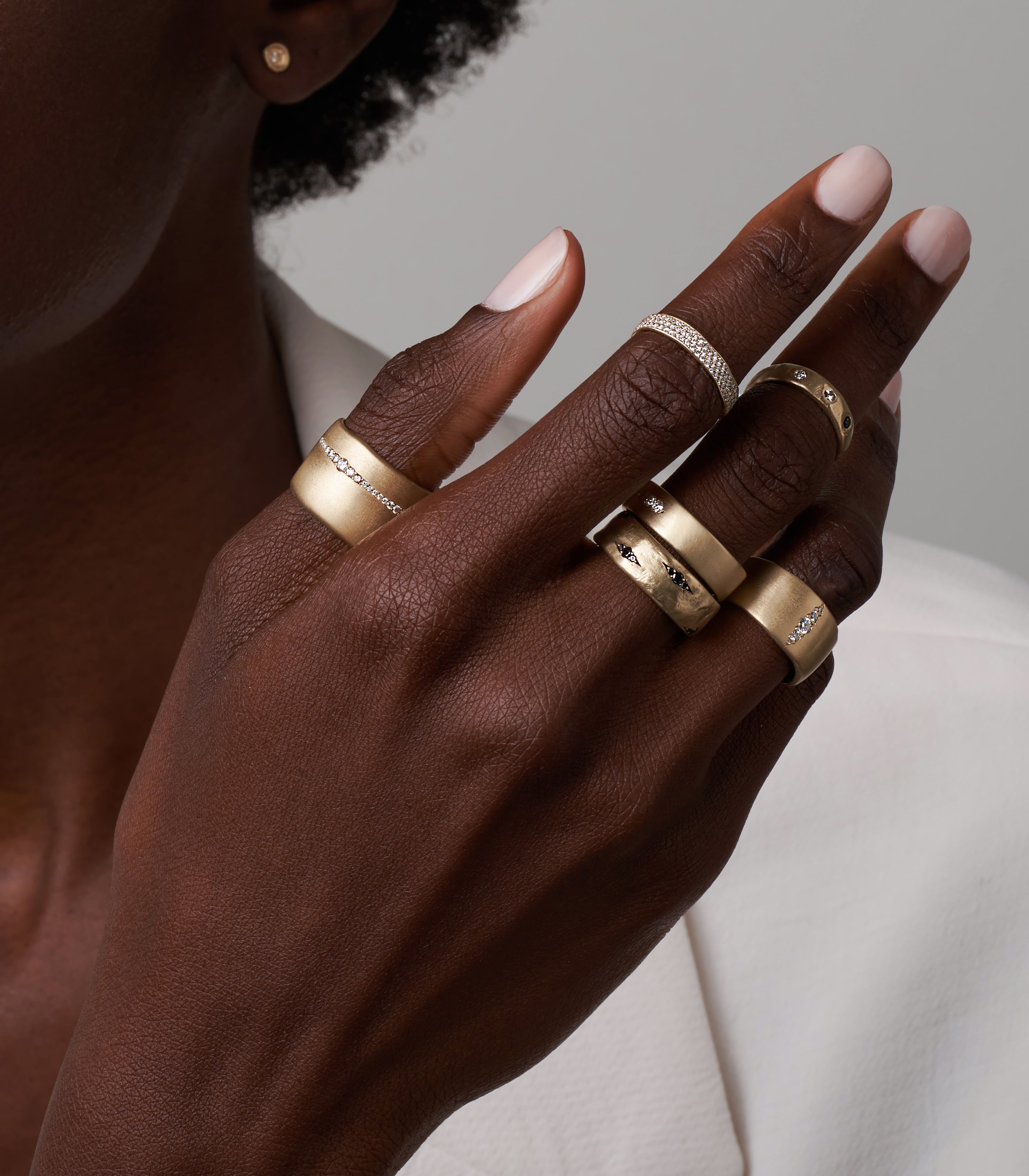 Dark and Mysterious GN-R1 shiny gold band rings with matte edges on a hand, sparkling stones