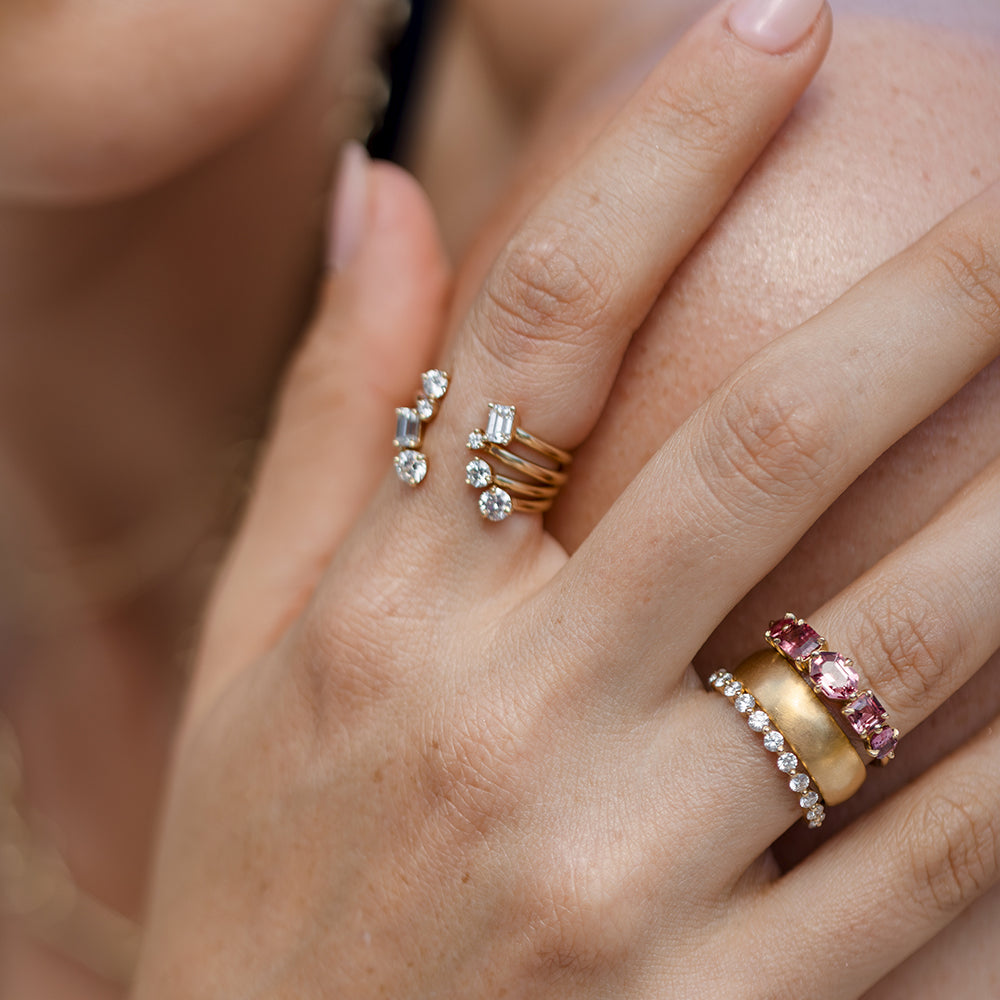 Claudette 5 Stone Band SK-R68B-5-MC-PS-1.64 gold ring band with five sparkling stones on a hand.