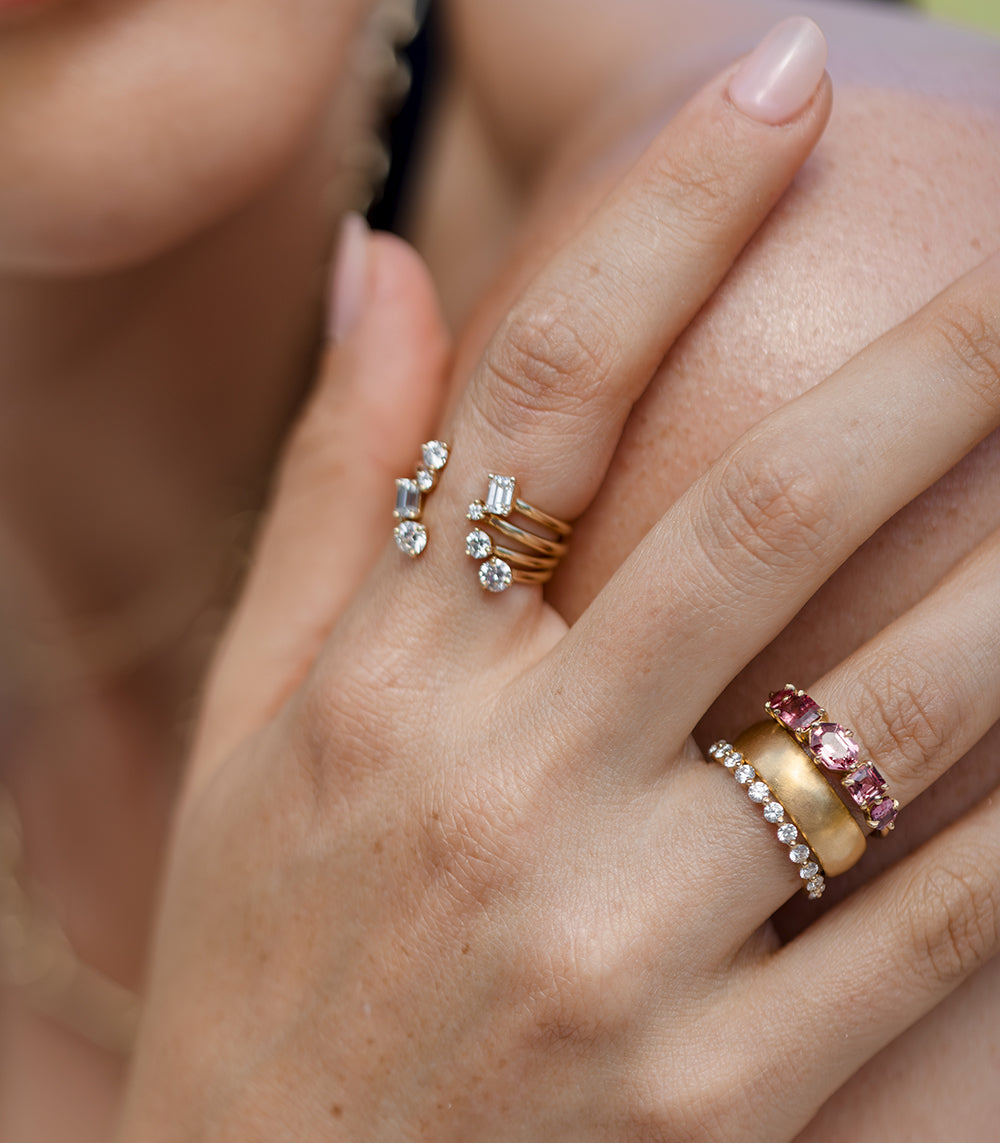 Claudette 5 Stone Band SK-R68B-5-MC-PS-1.64 gold ring band with five sparkling stones on a hand.