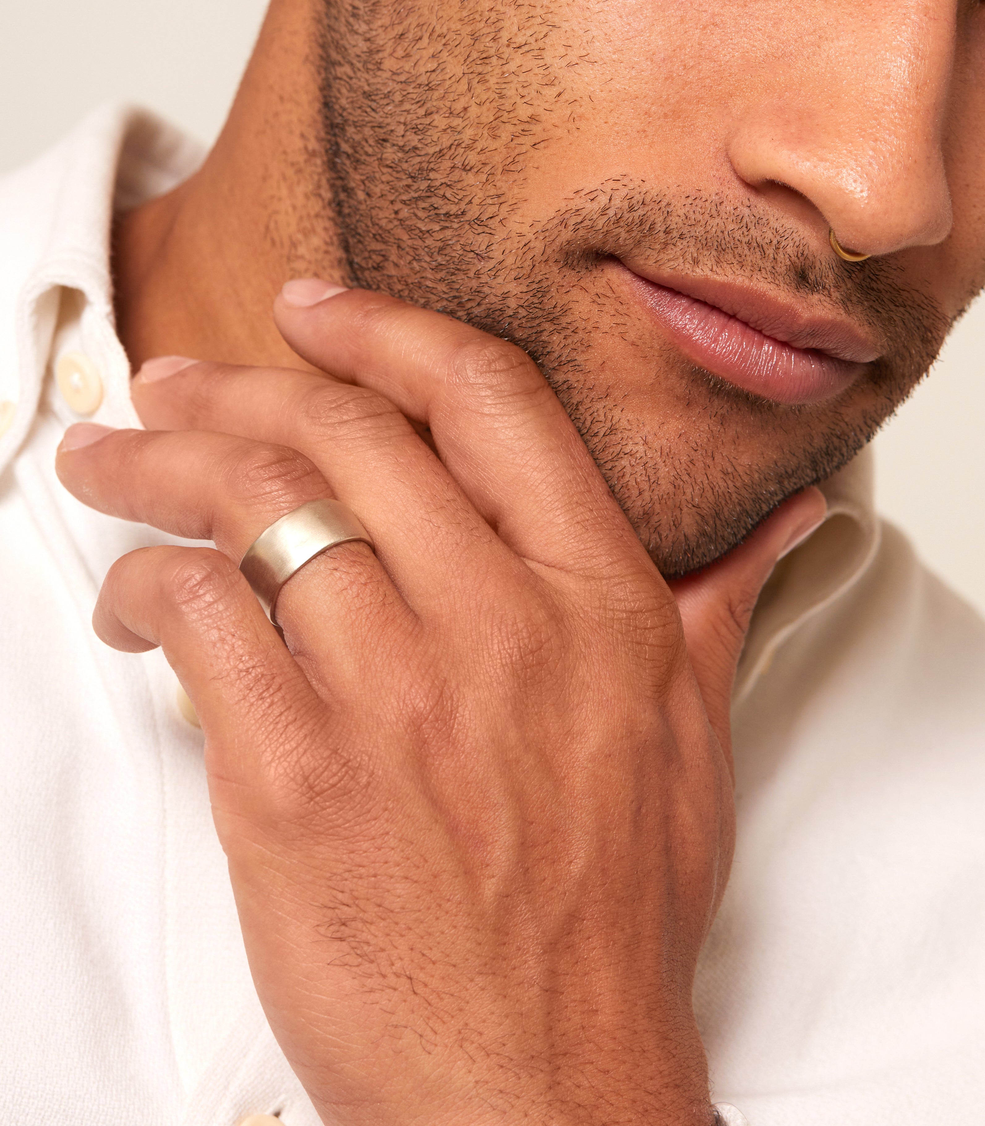 Torn Paper Wedding Band by M-R4-10 in warm gold, matte texture seen on a couple’s hands.