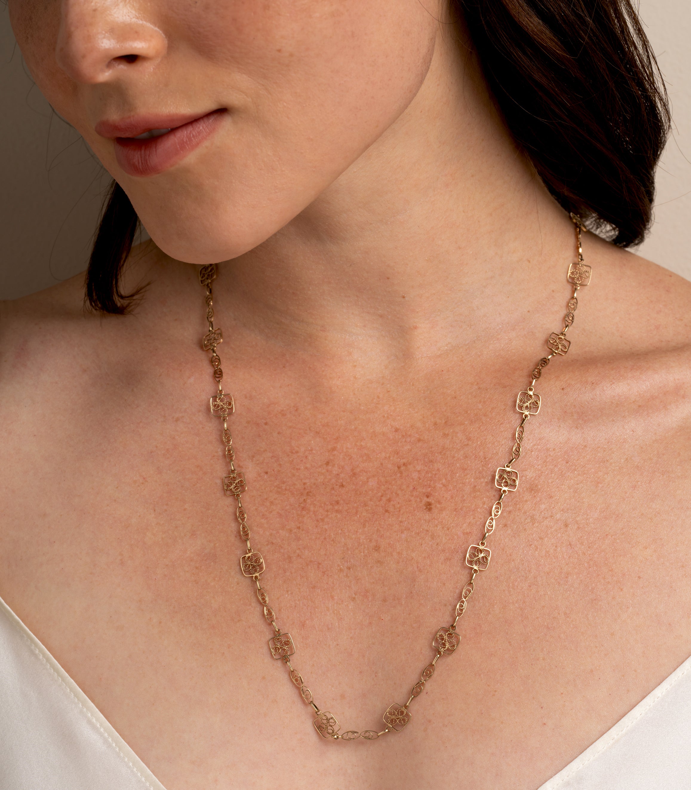 Lacy Links by VC-N69 gold necklace with lacy square charms and delicate chain links on model
