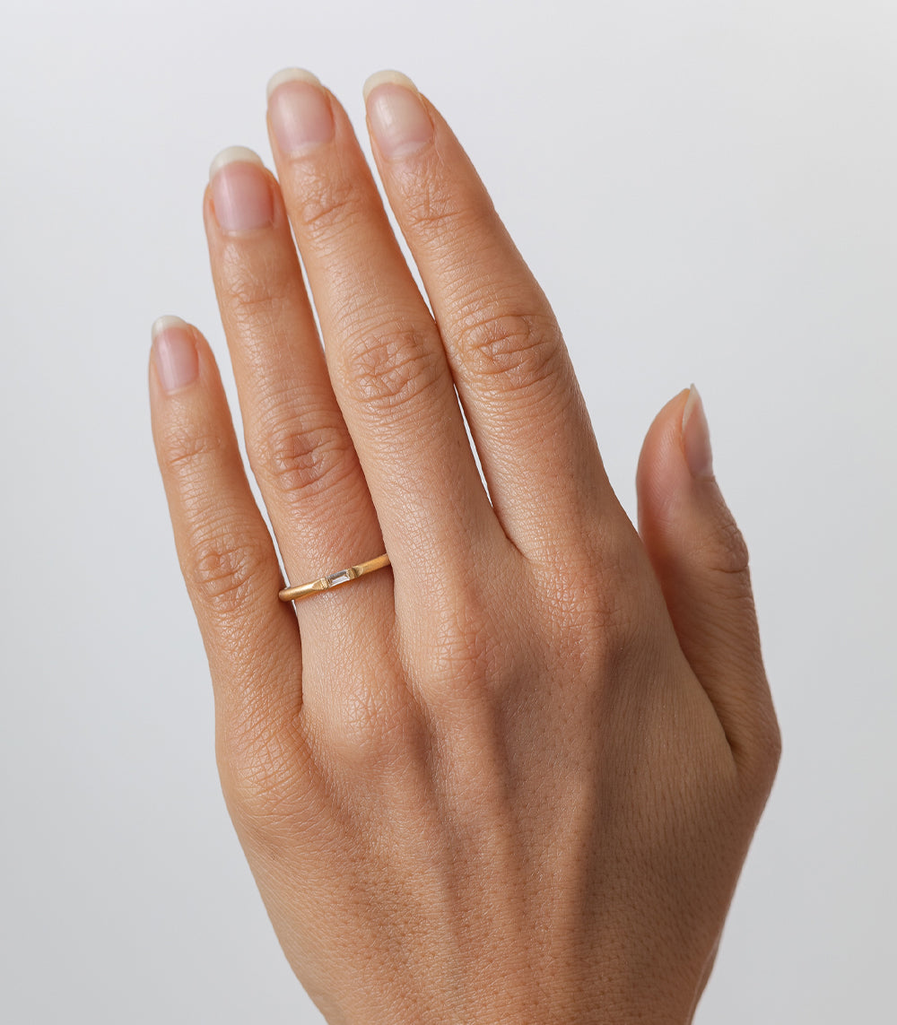 Wire Band by R-R7 14K yellow gold wire ring with smooth shiny finish on hand, close-up.
