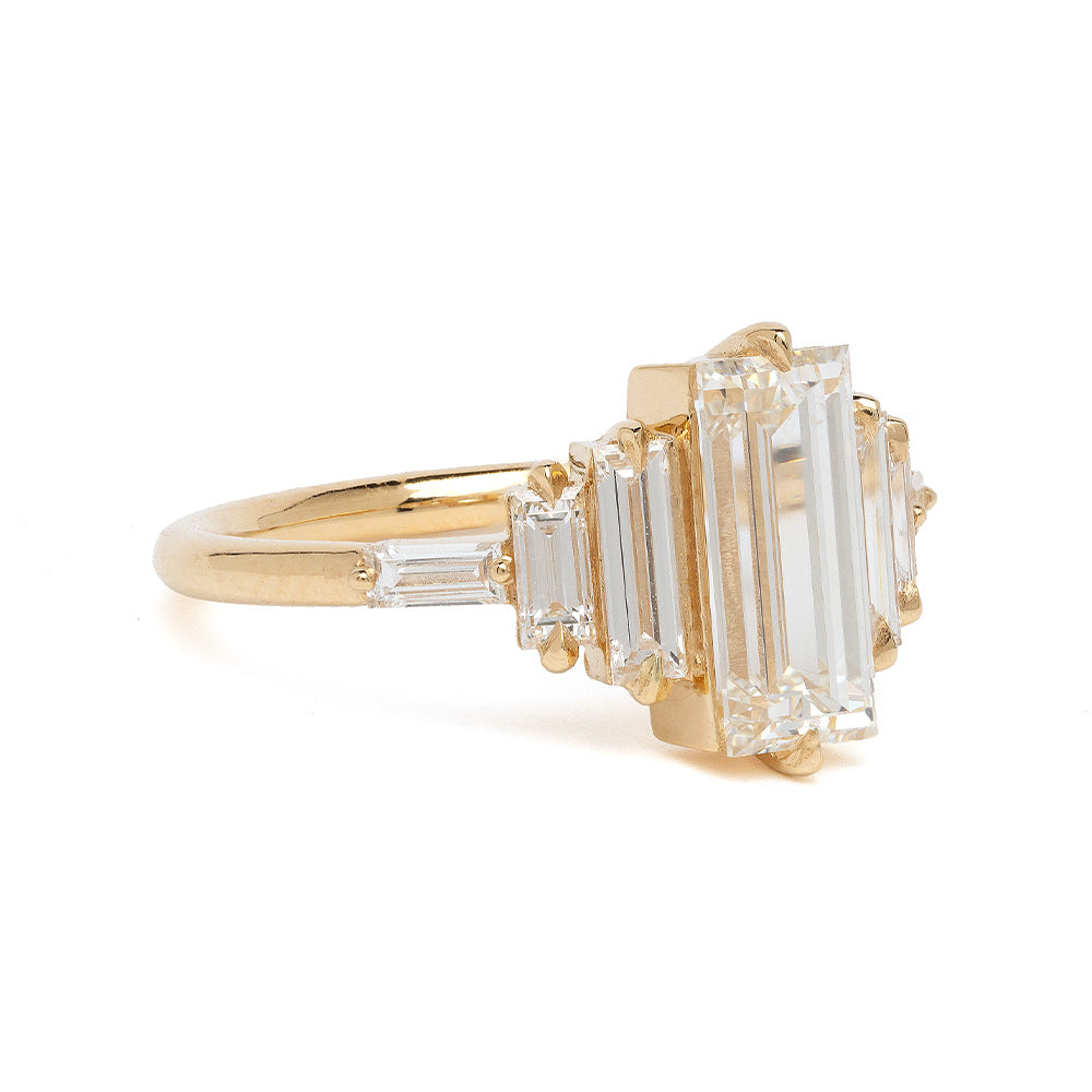 Ingrid SK-R100-ND-1.50 gold engagement ring with emerald-cut clear stone and baguette details.