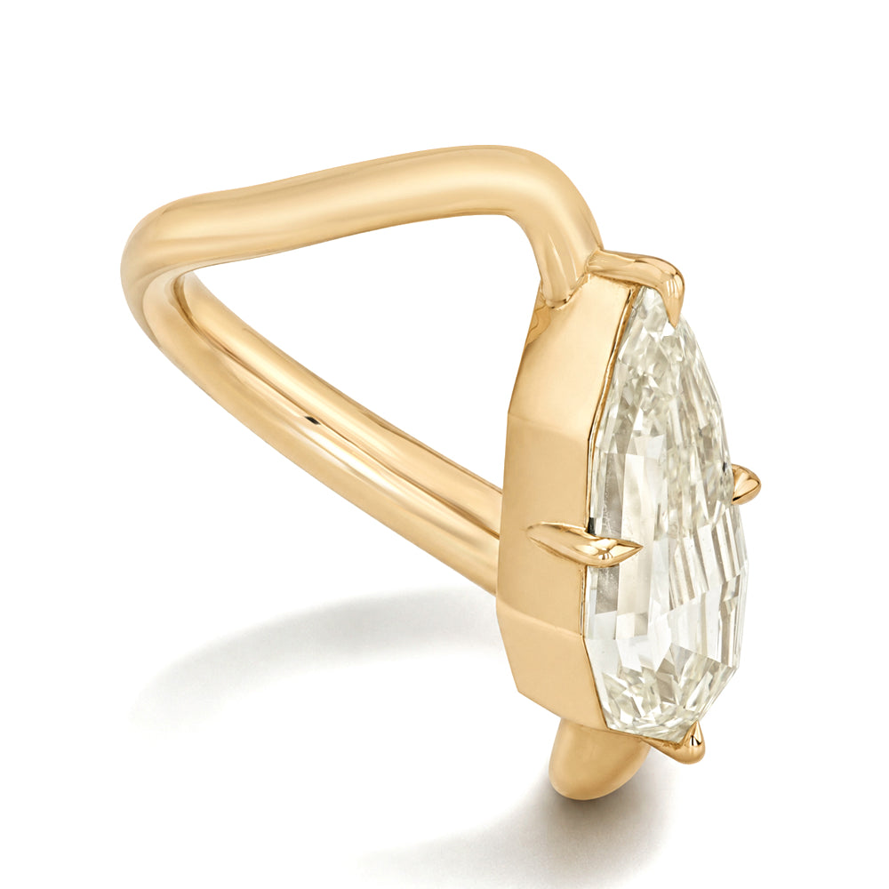A gold ring featuring a large pear step cut champagne diamond in a prong setting, shown on a clean white background.
