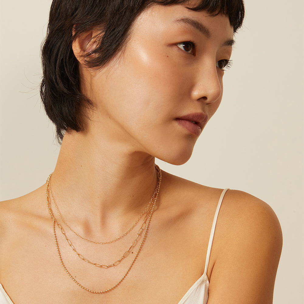 The Mod CN-C6 layered gold necklace with three chain lengths, 16 to 22 inches on model