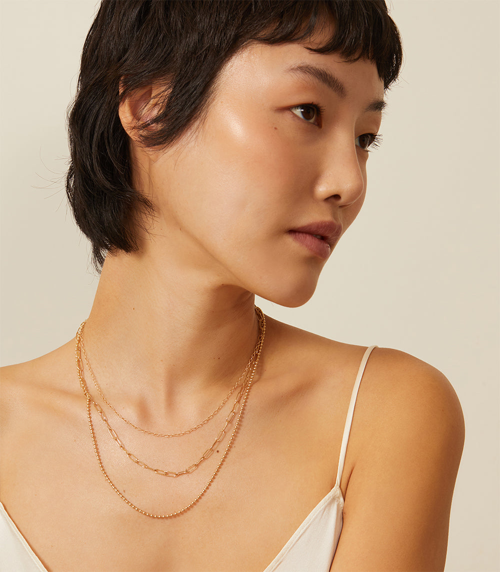 The Mod CN-C6 layered gold necklace with three chain lengths, 16 to 22 inches on model
