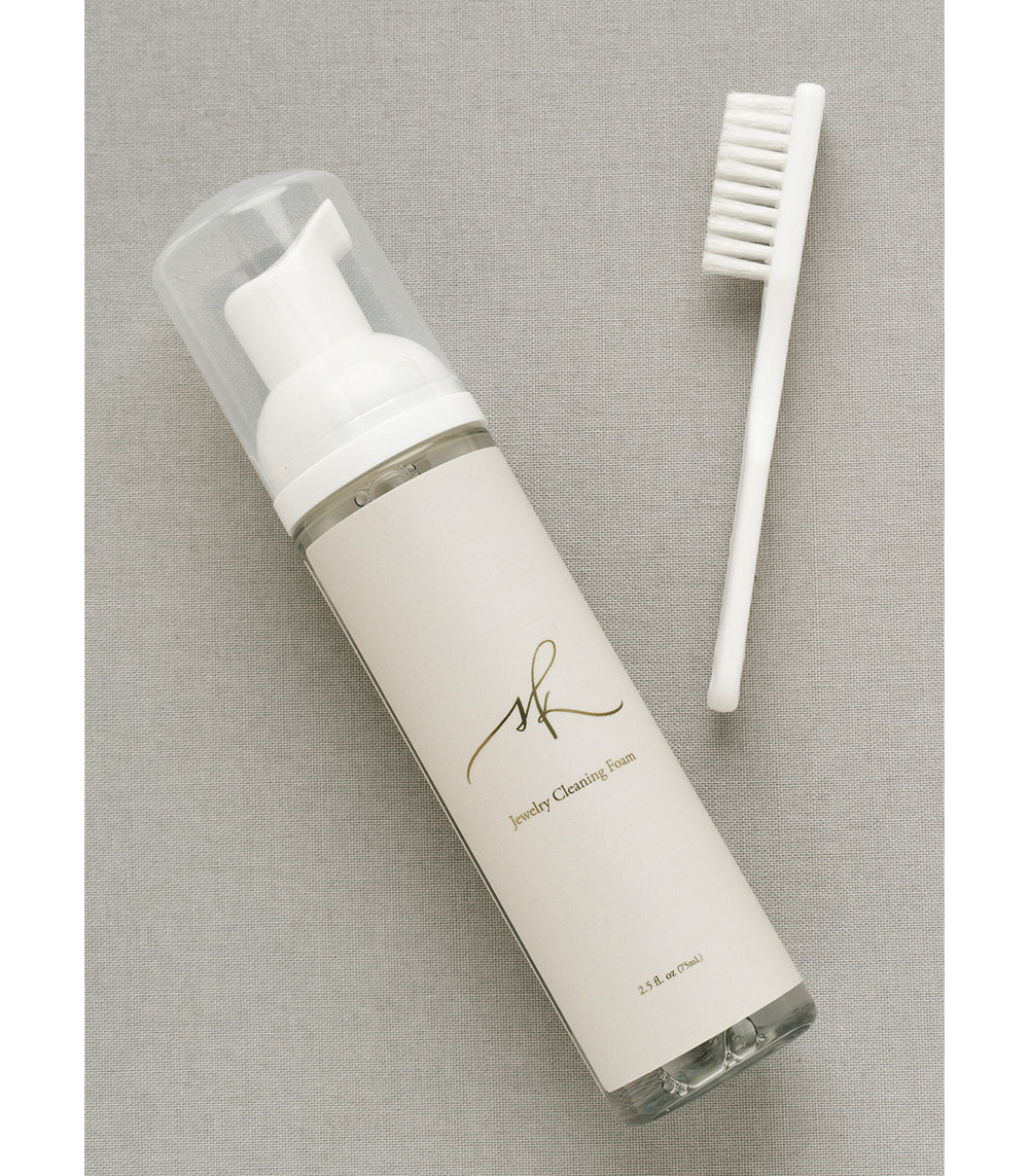 Jewelry Cleaner by G-001-Lavish with white brush and foam bottle on beige fabric background