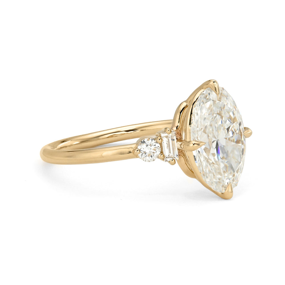 Gold ring with a large diamond and smaller side stones on a white background