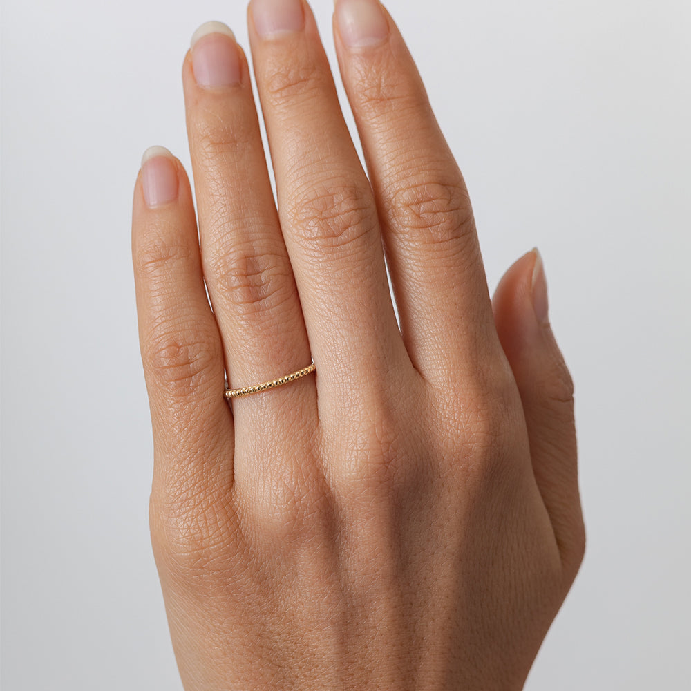 Beaded Band A-R11 14K yellow gold ring with small bead texture, subtle shine on hand