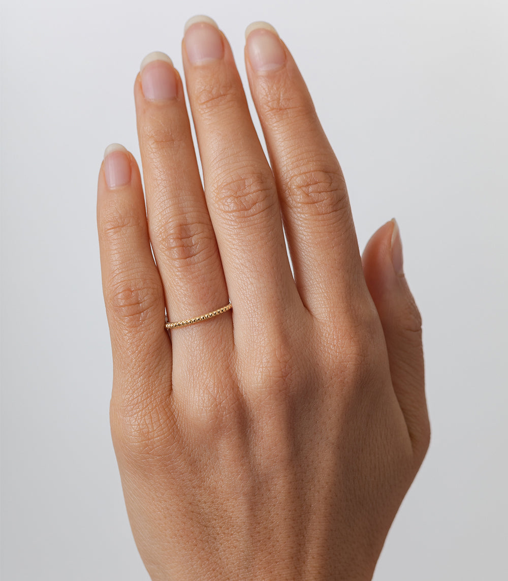 Beaded Band A-R11 14K yellow gold ring with small bead texture, subtle shine on hand